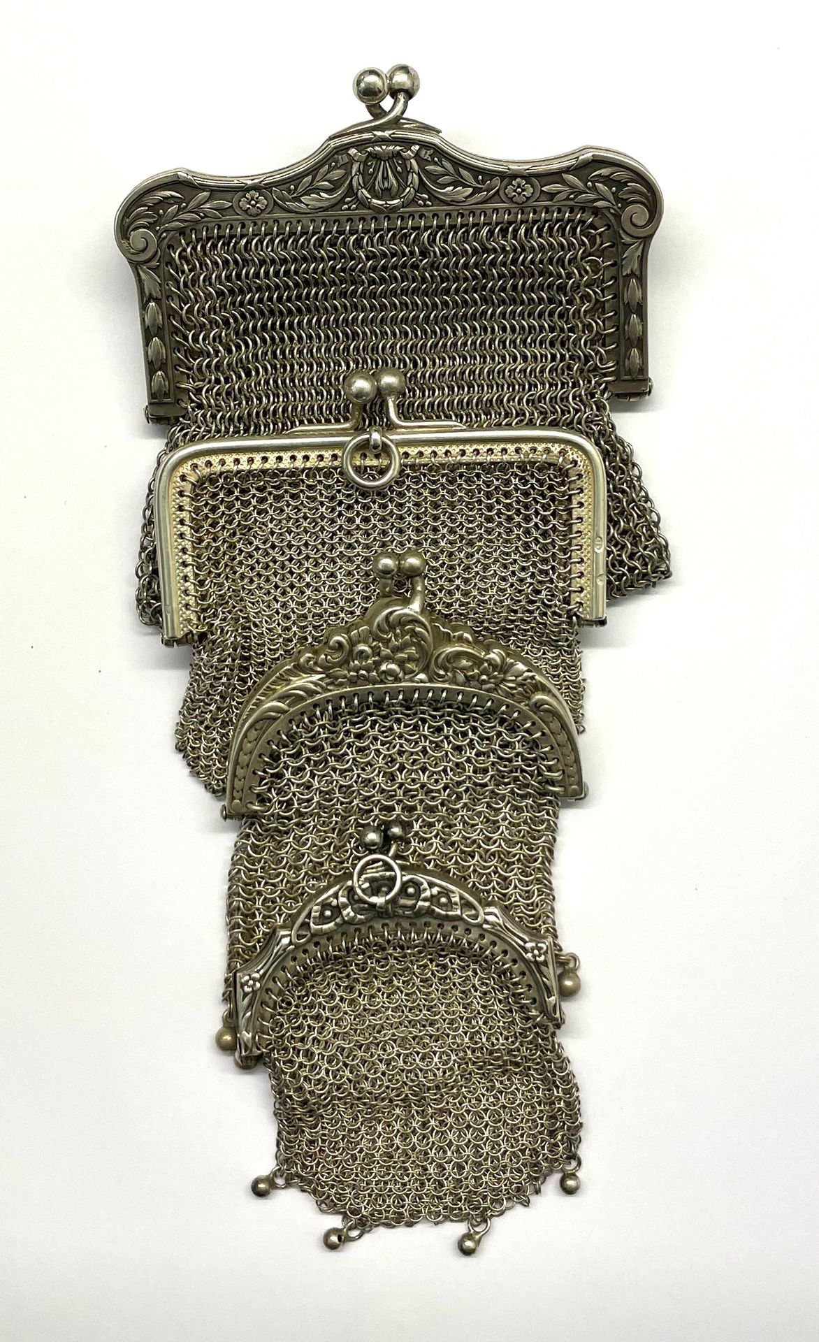 Null 一套四个带夹子开口的网状钱包，大部分都带着追逐的卷轴和花环，以流苏结束。

各种尺寸

毛重：158克

材质 : 银色

状态 : 完好