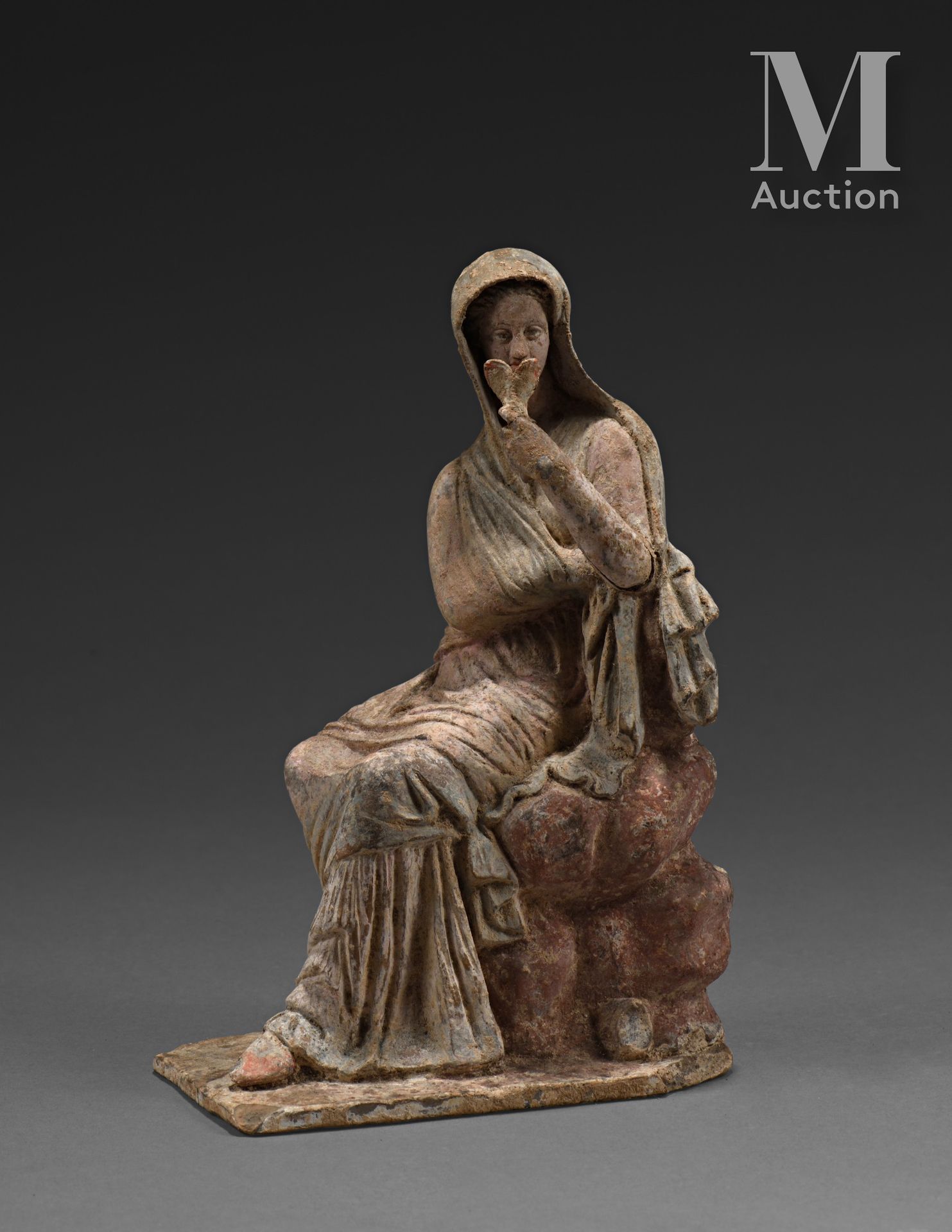 Figurine féminine assise sur des rochers, le corps de trois-quarts tourné gauche&hellip;