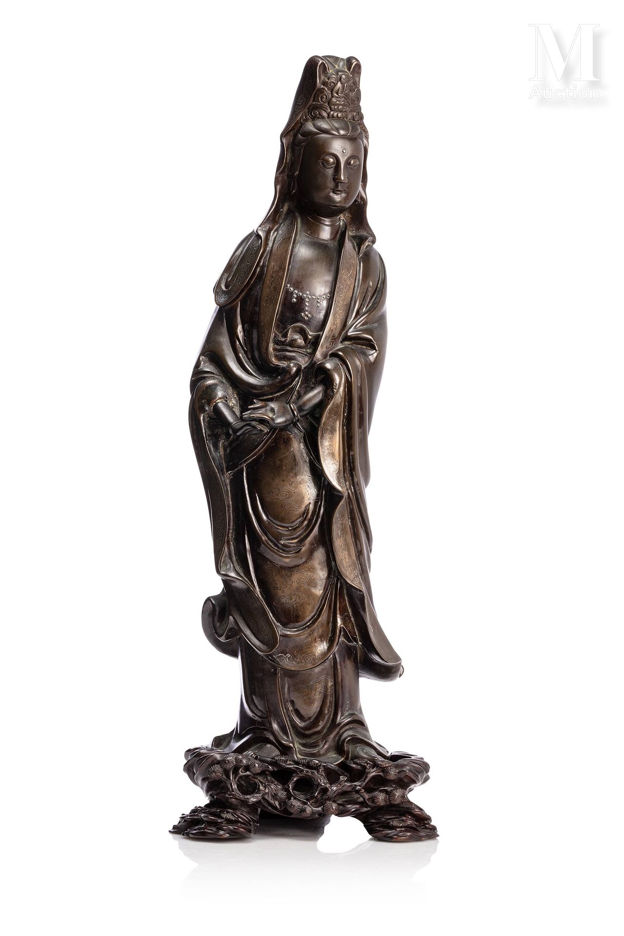 CHINE, XVII-XVIIIe siècle 
重要的青铜观音

她被描绘成站立，双手抱在身前。她身穿镶嵌有银色云纹的长袍，头发梳成高高的发髻，上面有佛像&hellip;