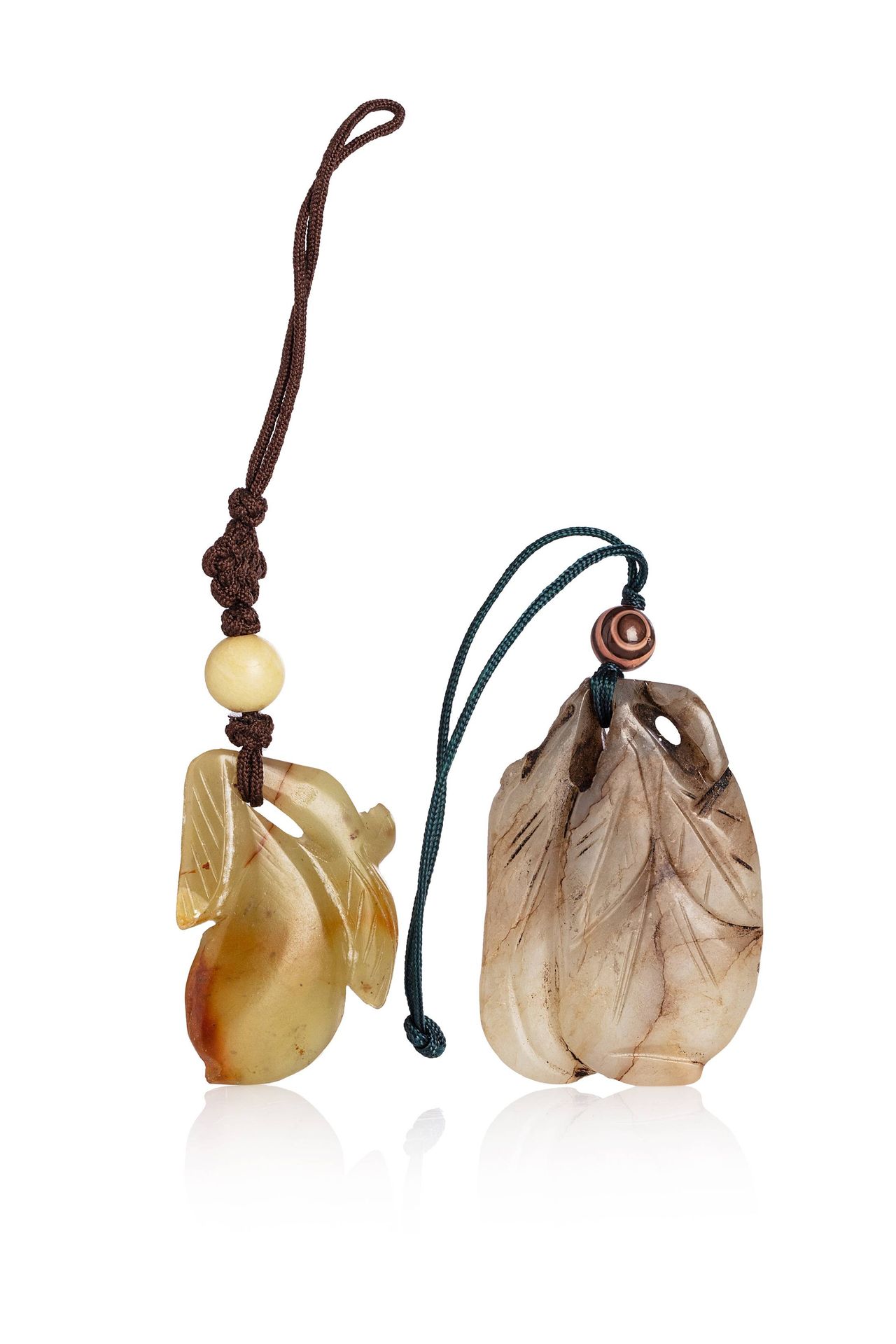 *CHINE, vers 1900 
Deux pendentifs en jade A forme de fruit et branche. La pierr&hellip;
