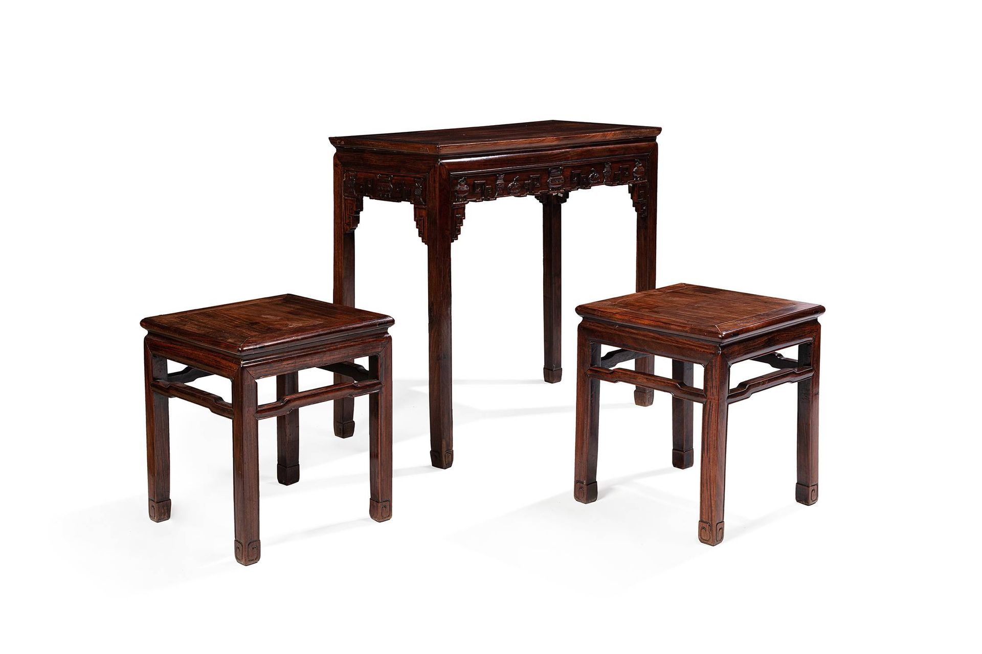 CHINE, XIXe siècle 
Tisch und zwei Hocker aus geschnitztem Hongmu-Holz.

Hocker:&hellip;