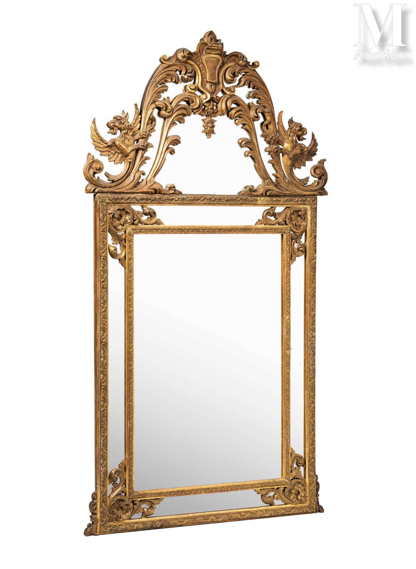 Miroir à parcloses inscrit dans un cadre en bois sculpté et doré surmonté d'un f&hellip;