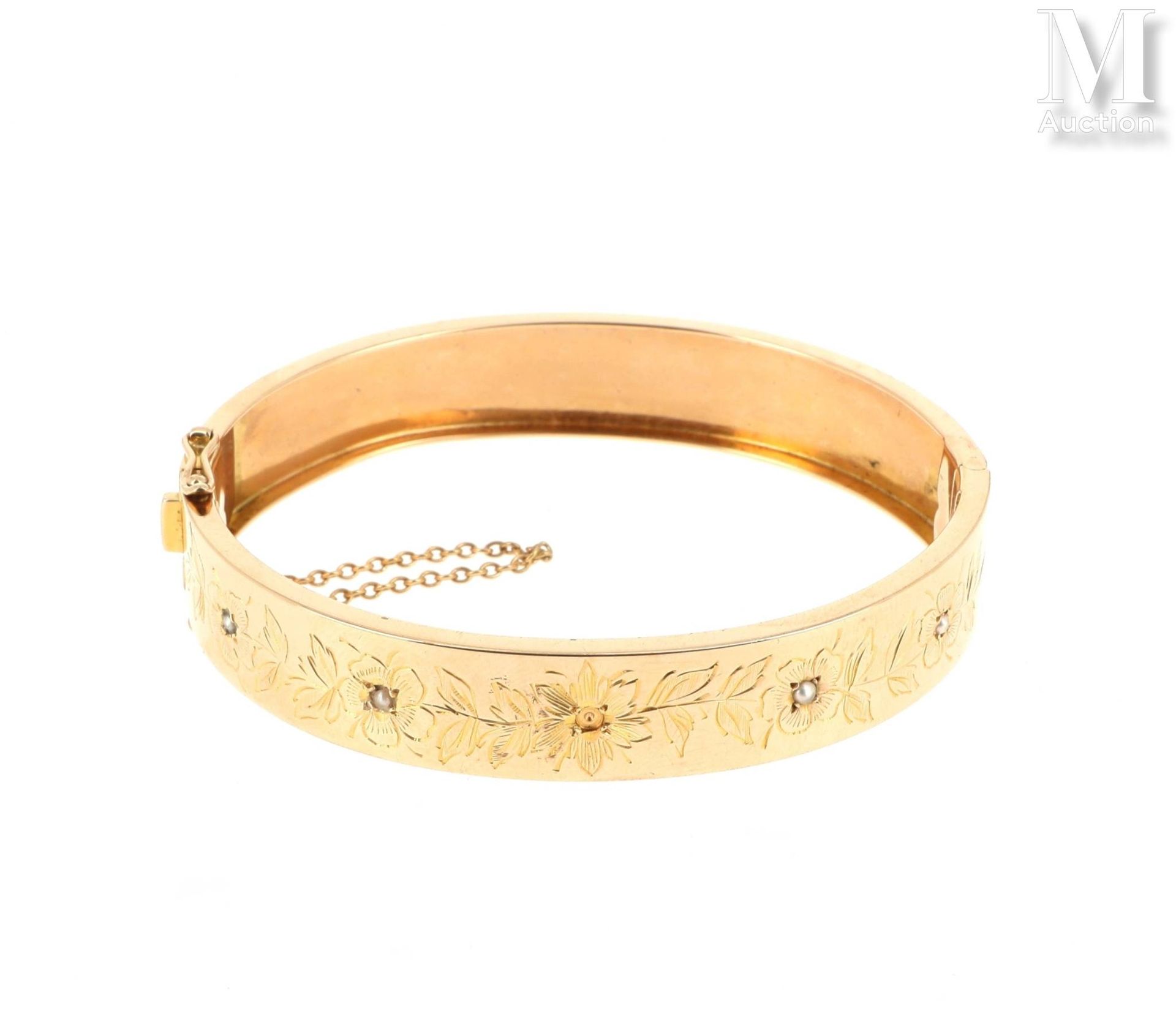 Bracelet jonc 18K（750°/°）黄金椭圆手镯，凿刻花纹卷轴装饰，镶嵌小珍珠（缺失）；铰链式侧开，棘轮扣，带八字和安全链。

毛重：19,1克。&hellip;