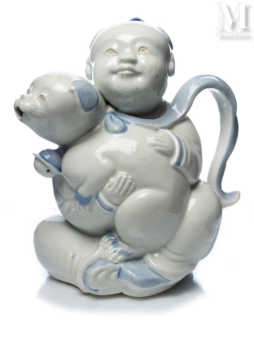 JAPON, XIXe siècle 漂亮的平户瓷器茶壶

形状是一个坐着的孩子，怀里抱着一只小狗，狗的丝带形成手柄，嘴形成喙，孩子的衣服上有云彩装饰。
高度：&hellip;