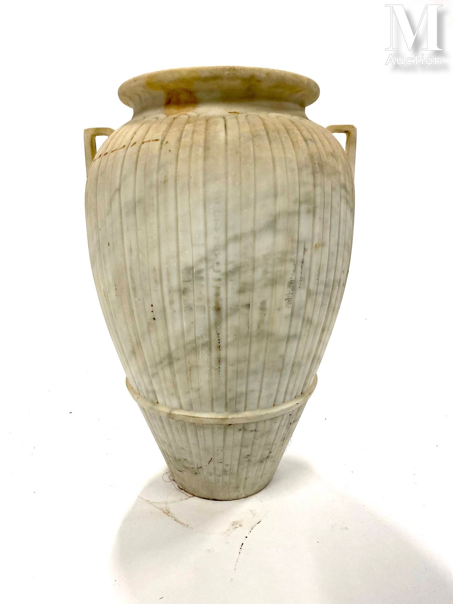 Vase en marbre con due maniglie, il fusto con decorazioni a gadroon
H: 48 cm.