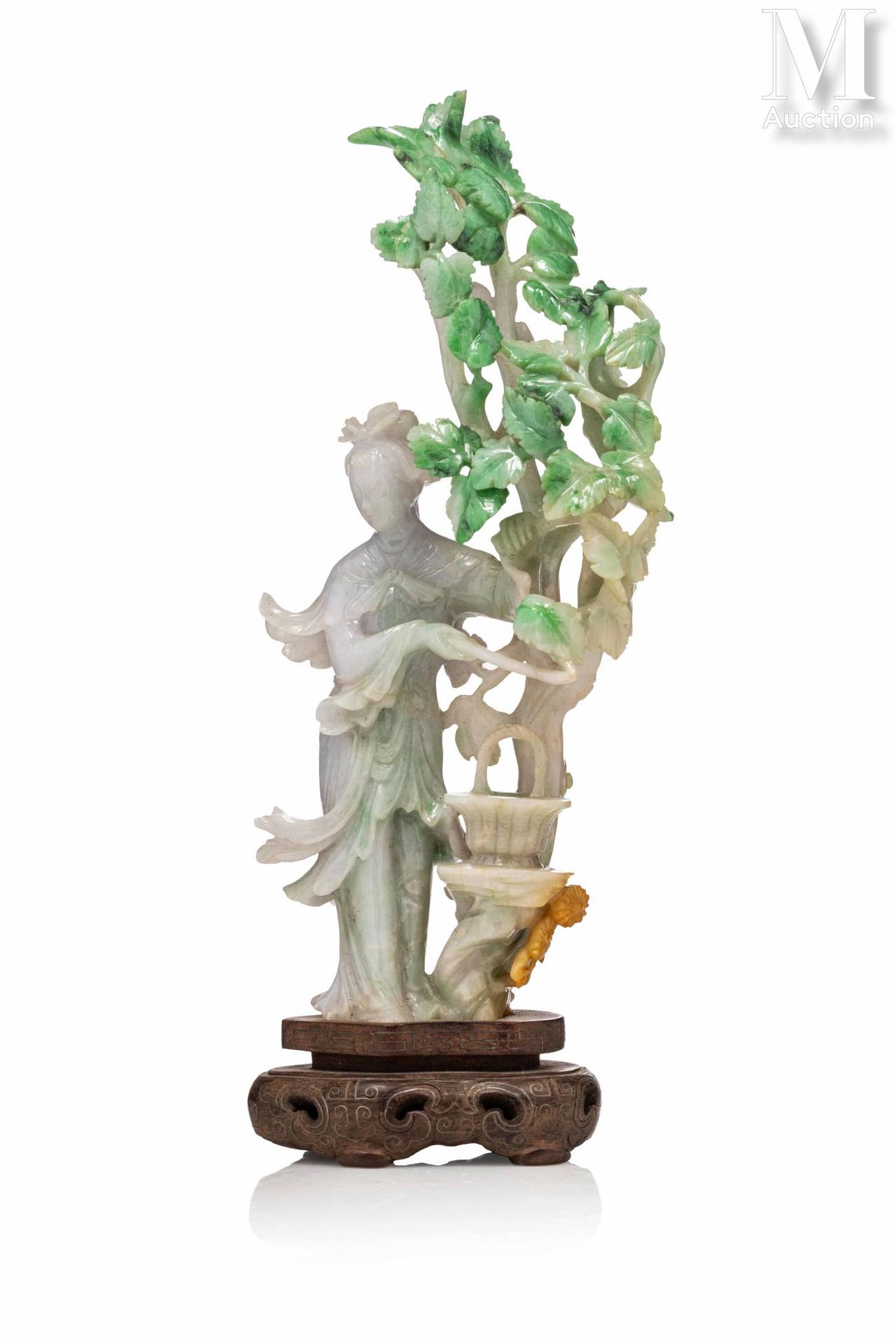 CHINE, XXe siècle 翡翠雕像

描绘了一个优雅的女人站在树叶下的篮子旁，石头的颜色是浅绿色的，带有苹果绿的色调，略带铁锈的味道。有合适的木质底座&hellip;