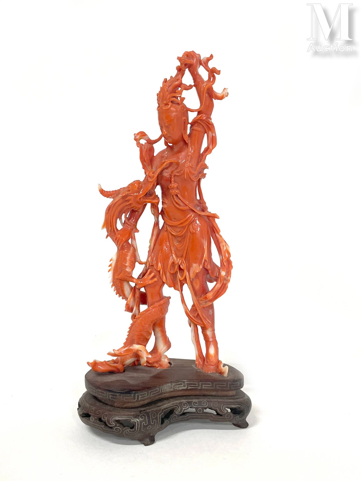 CHINE, XXe siècle 橙色珊瑚雕像

表现了一个站立的观世音菩萨挥舞着她的金刚杵向一条身体缠绕在她腿上的龙。放在一个合适的木质底座上。

高度：1&hellip;