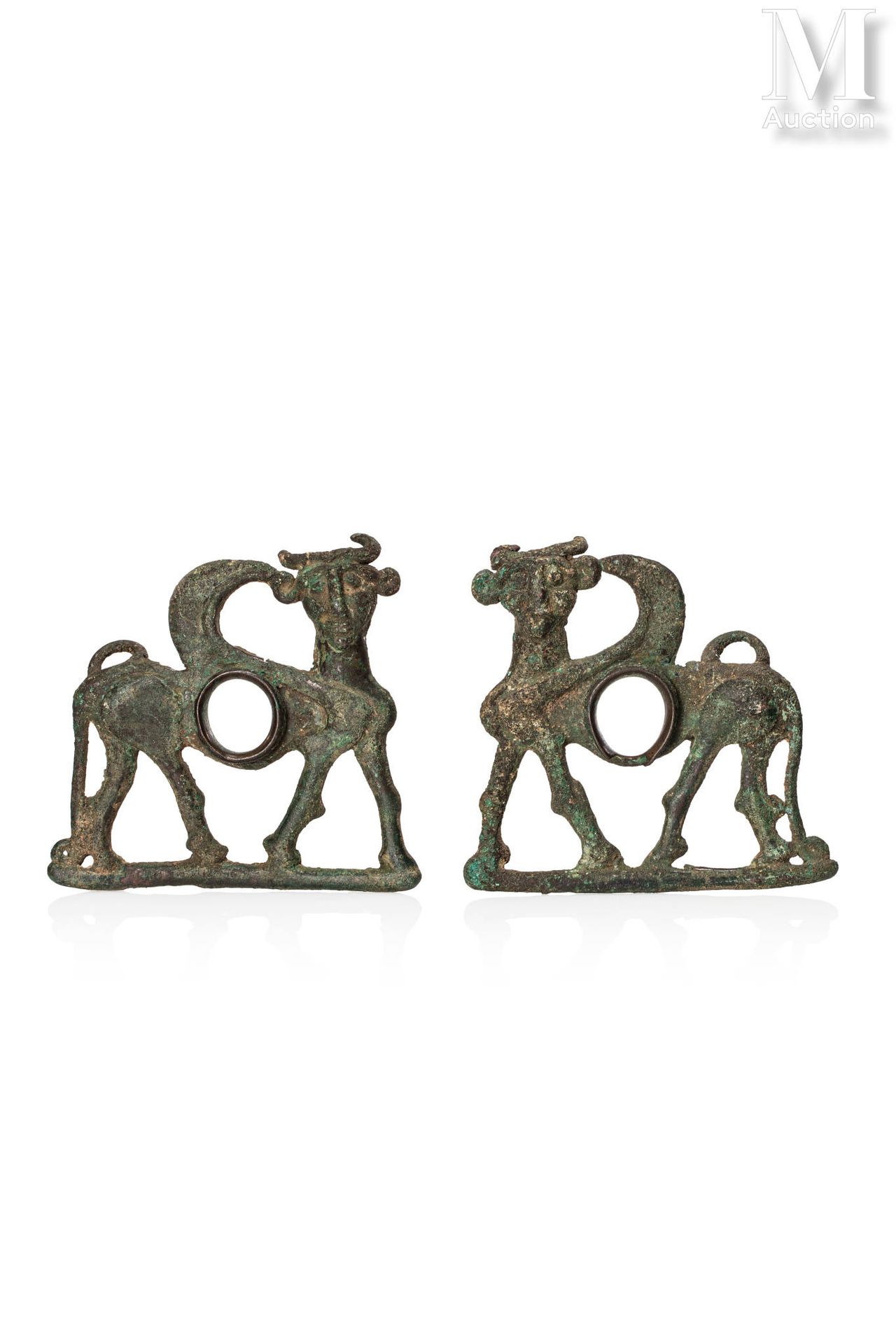 Paire de psalias in the form of winged bull genies. 
Bronze with green crusty pa&hellip;