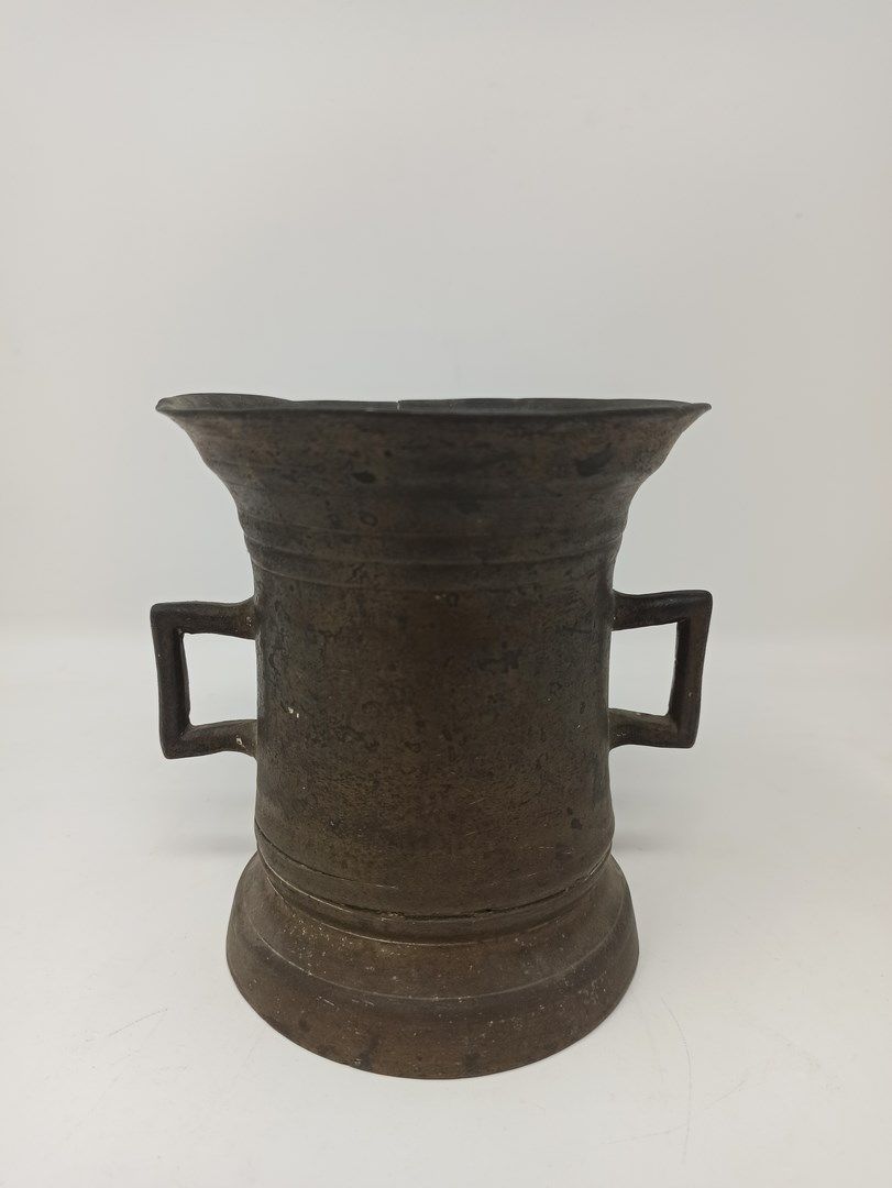 Null 青铜钵，模制的钵体和喇叭形的颈部，有两个长方形的把手。

18世纪

H.13,5 cm

(边缘的小事故)