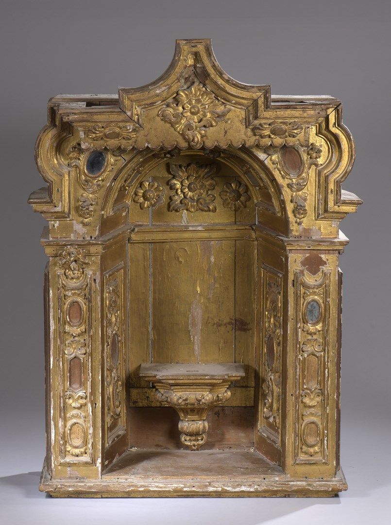 Null 一个大型的雕刻和镀金的树脂木壁龛，装饰着卷轴和花朵，并有储备金；里面有一个放置雕像的控制台；镜子镶嵌。

意大利，18世纪

高：137厘米 - 宽：&hellip;