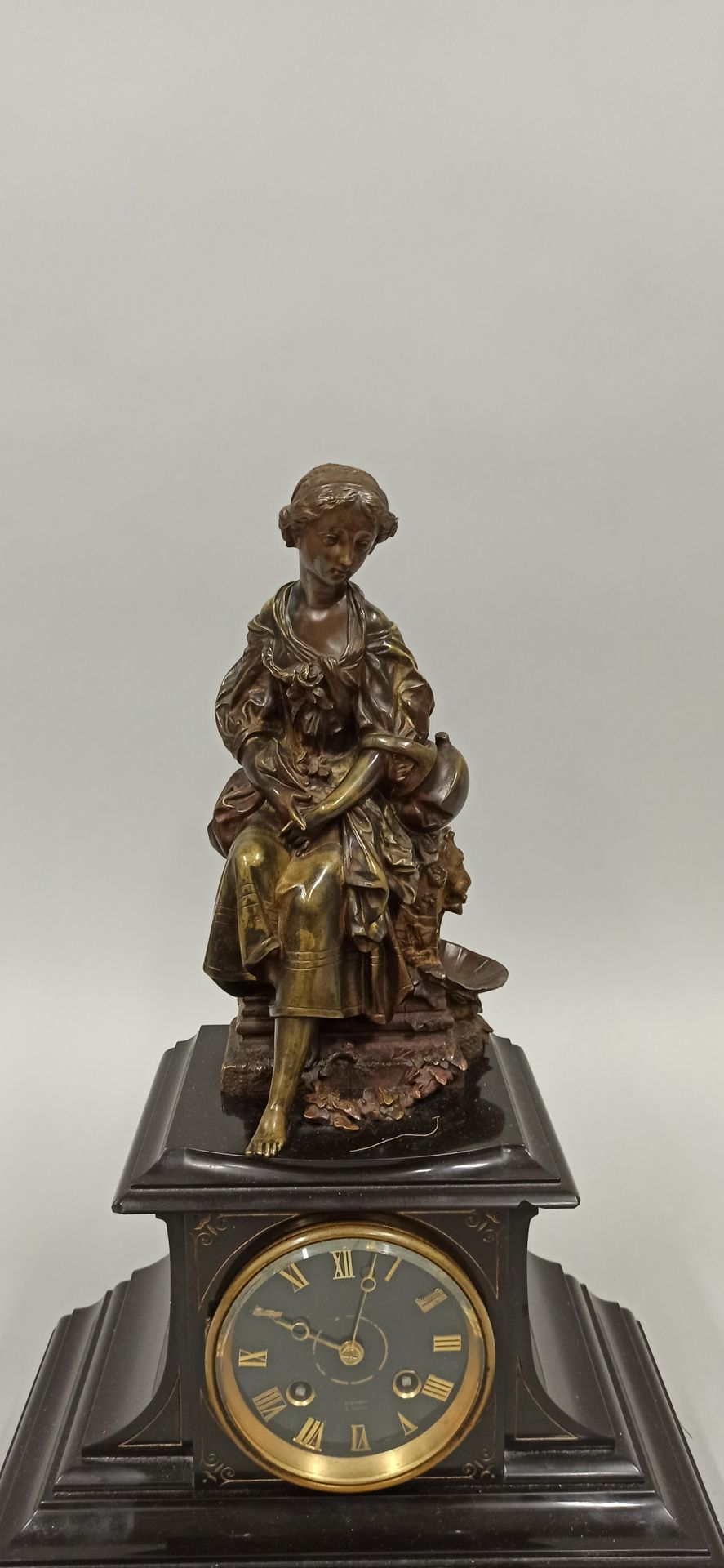Null 一个终端时钟，上面有一个带着花环的年轻女孩的青铜雕塑，署名Jules Salmson（1823-1902），表盘上有罗马数字，署名Pierros in&hellip;