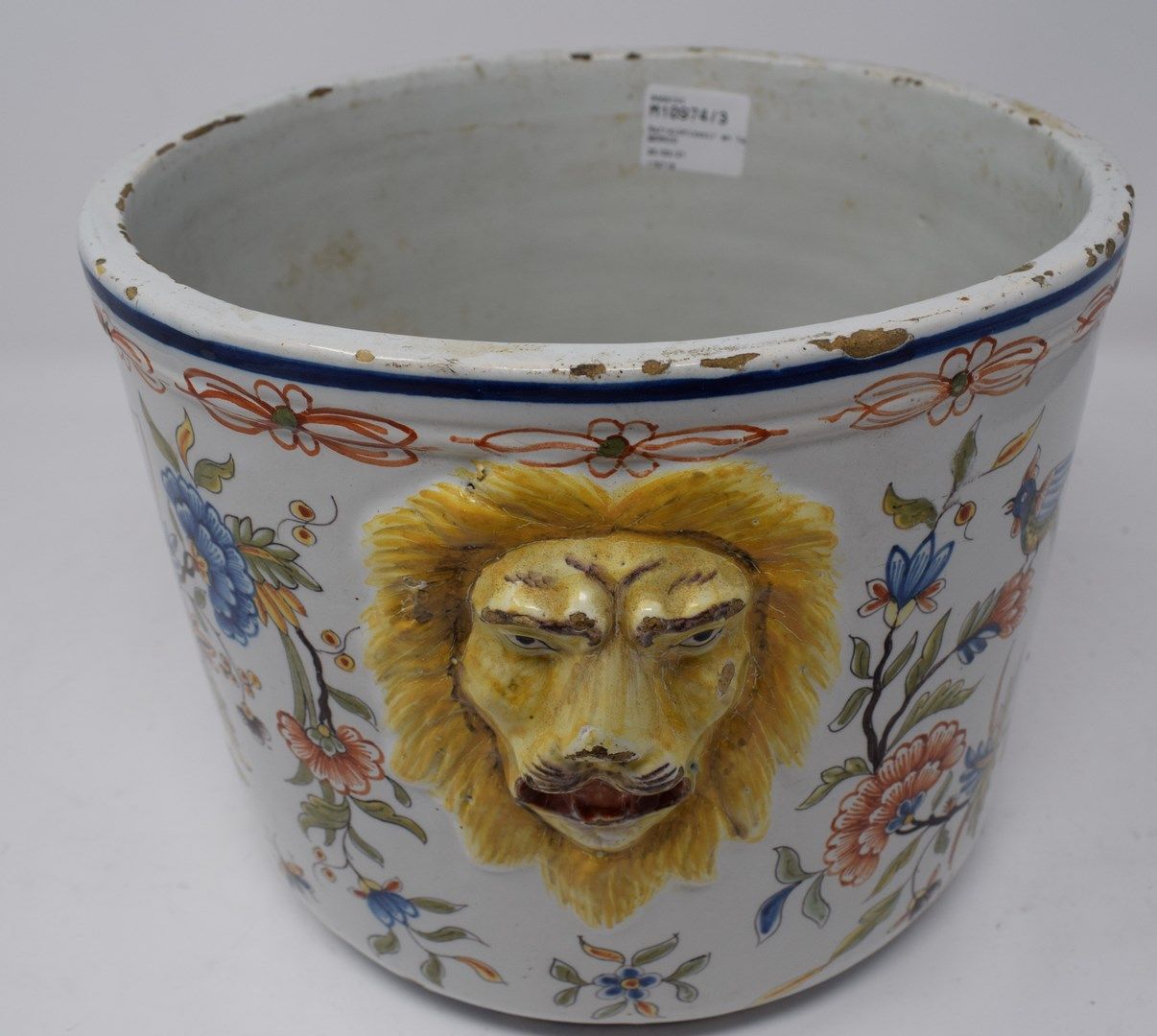 Null 一个鲁昂陶器茶点架，装饰着一个大角火，有一个狮子头把手。

19世纪的作品。

底部有钻孔，有缺口和各种划痕。