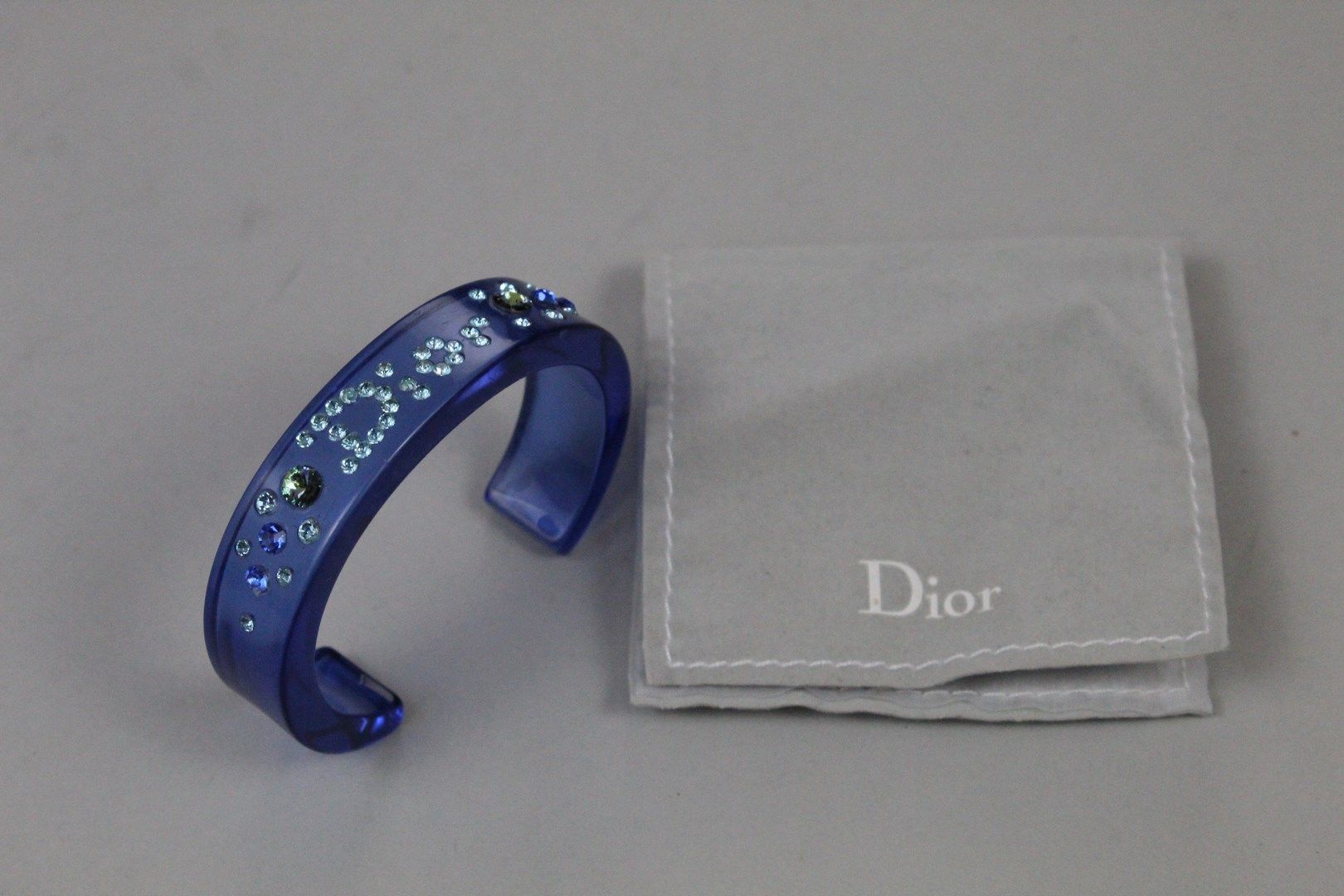 Null CHRISTIAN DIOR



蓝色有机玻璃手镯，装饰有水钻组成的 "DIOR "字母和风格化的花朵。



在它的袋子里。