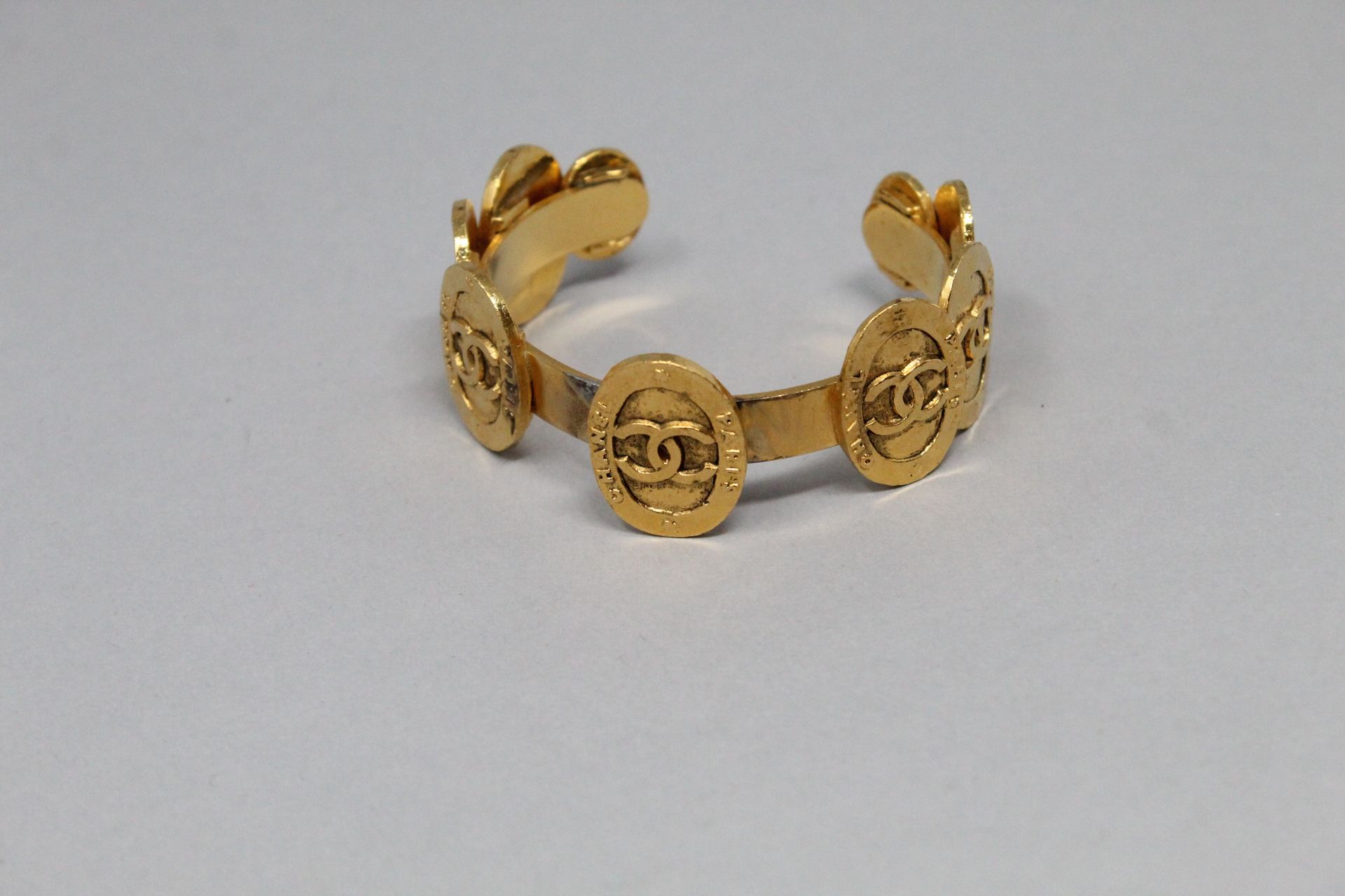 Null CHANEL 

Bracelet jonc en métal doré siglé Chanel.

Diam. : 58 mm. 

(Resta&hellip;