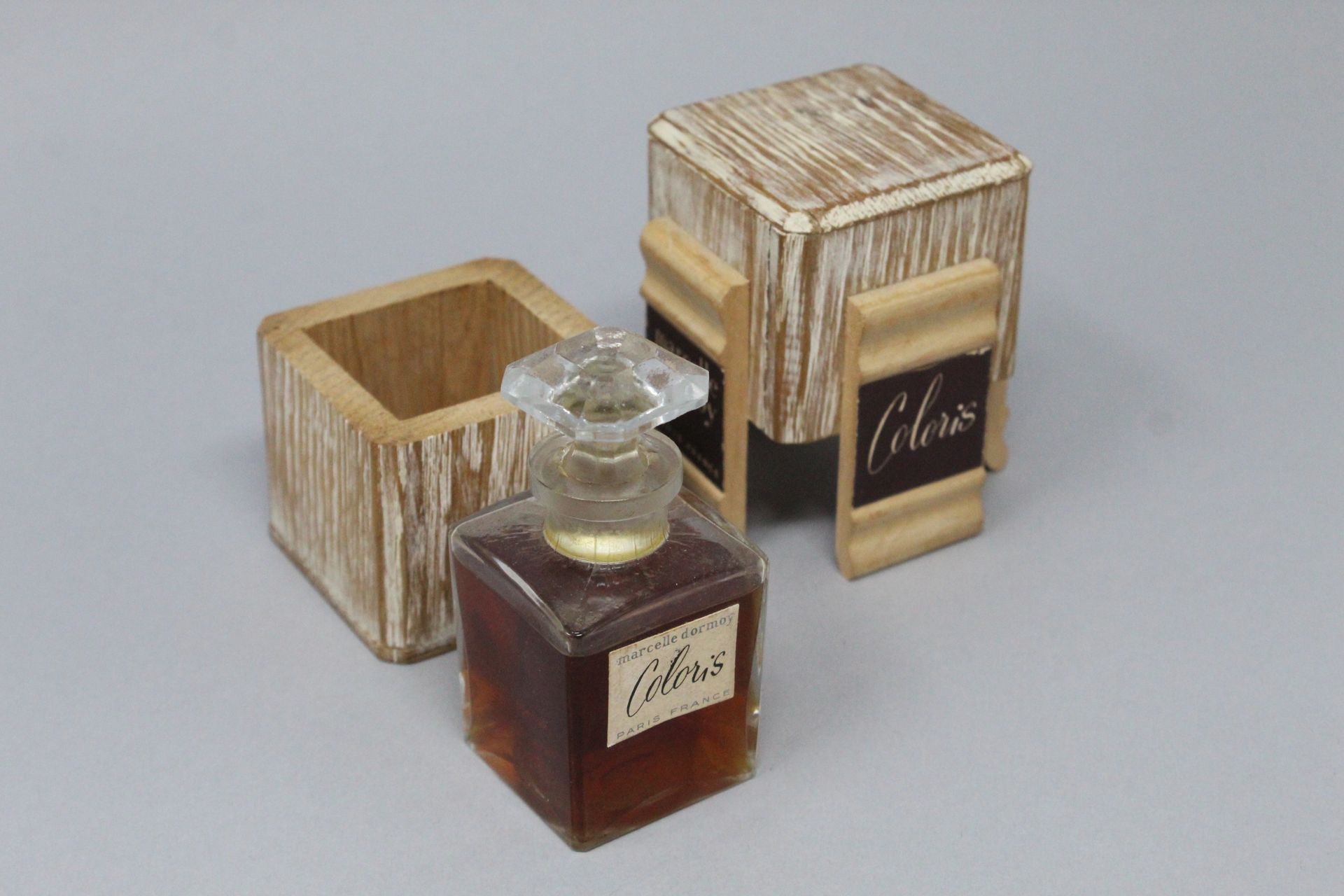 Null MARCELLE DORMOY "Coloris



玻璃香水瓶装在原来的木盒中，仍装有香水。
