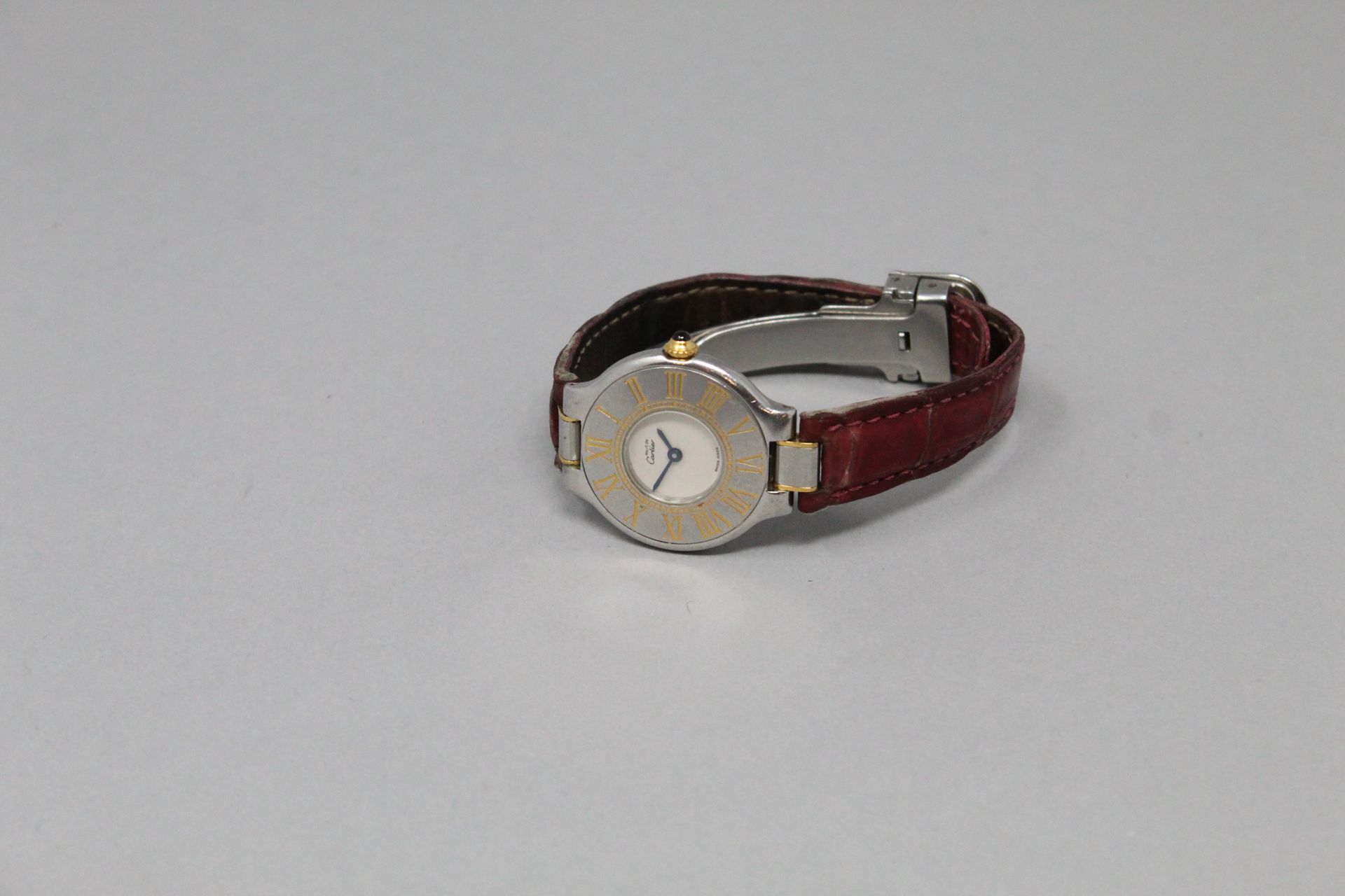 Null 卡地亚（必须的

手表，圆形金属表壳，奶油色表盘和蓝色指针。

表圈上刻有金色的罗马数字。

签名为Must de Cartier，"21世纪 "型号&hellip;