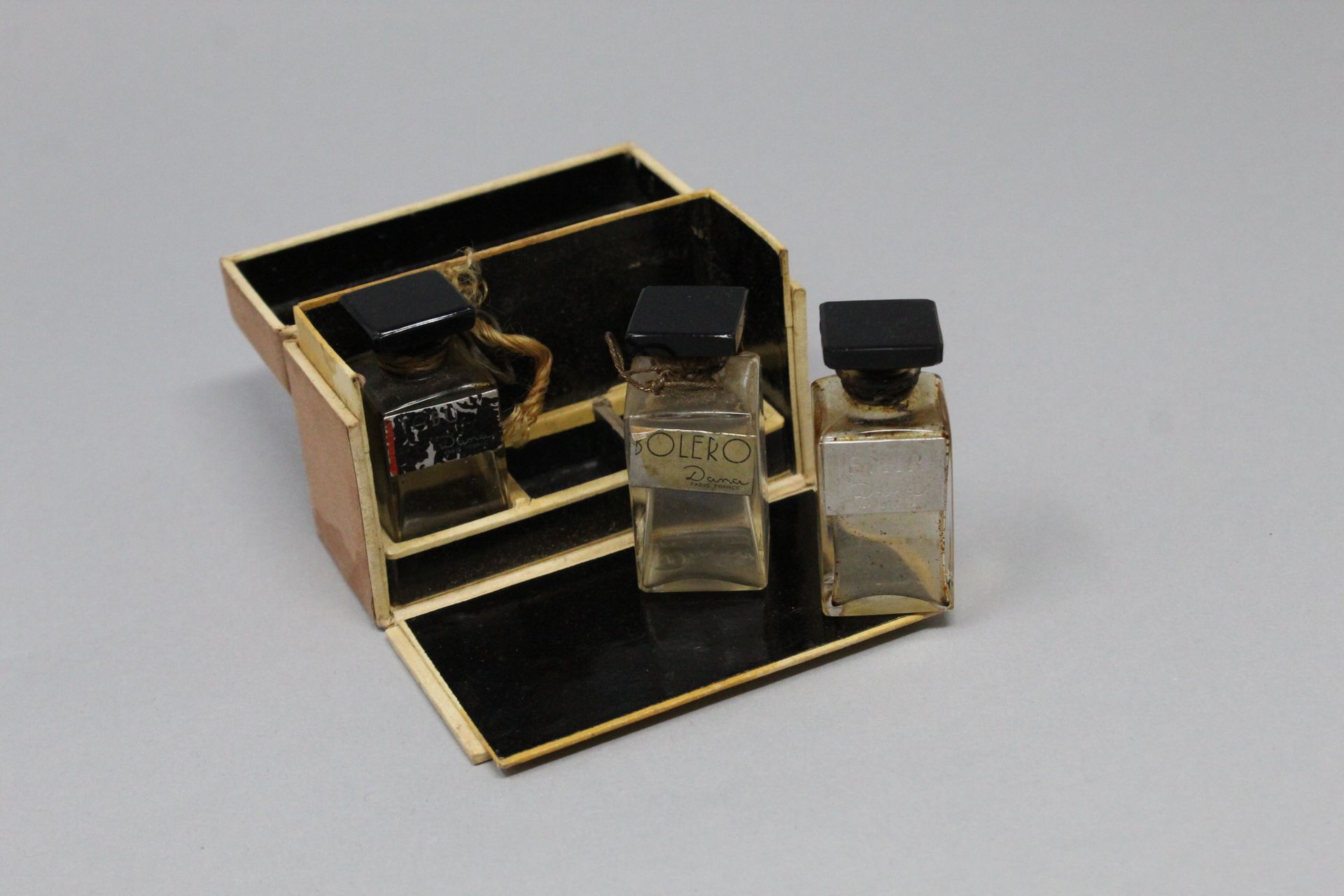 Null DANA



三个玻璃瓶的香水样品装在一个盒子里，包含 "Tabu"，"Bolero"，Emir"。



擦伤、污渍和磨损。
