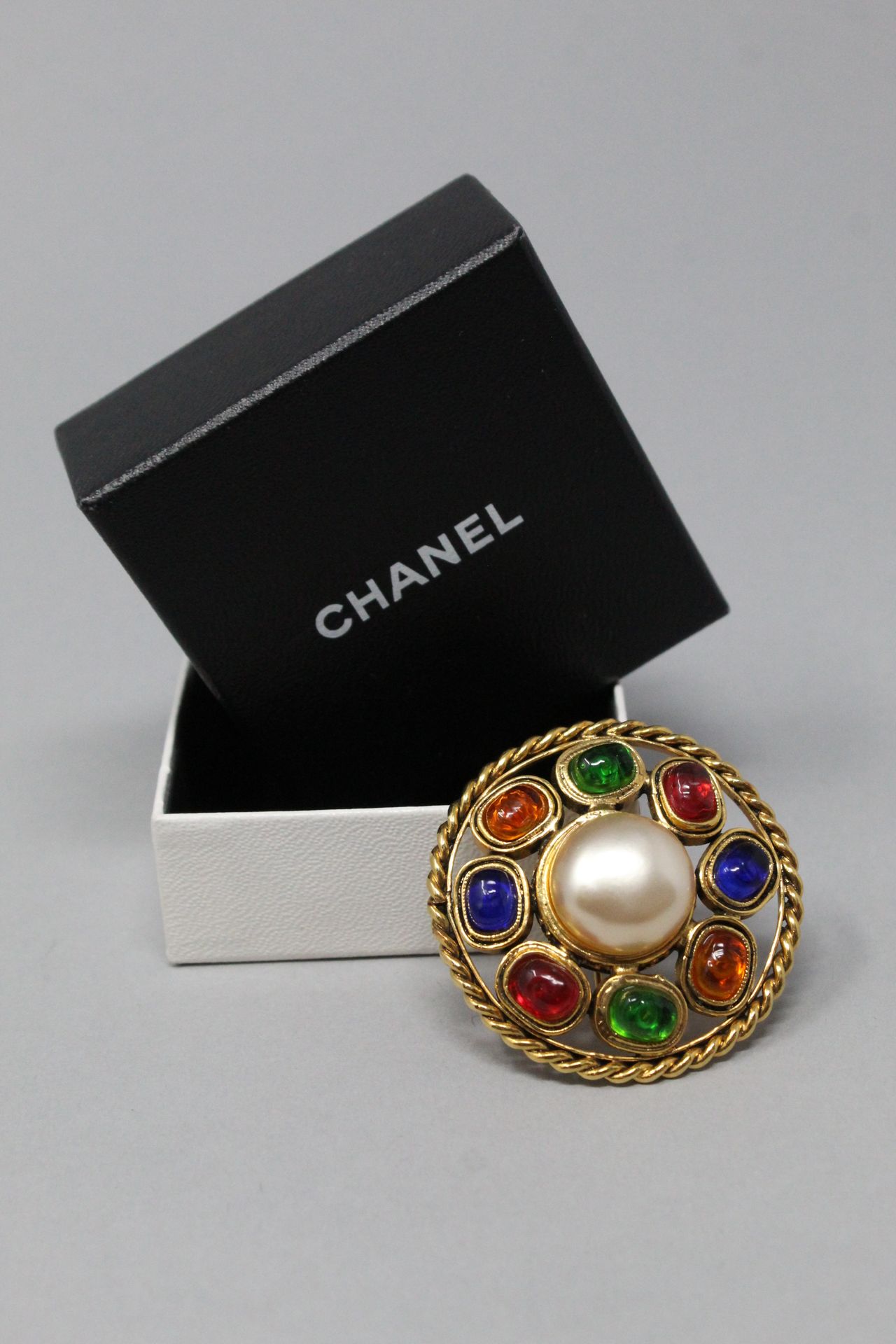 Null 
CHANEL

Broche ronde en métal doré ajourée, ornée d'une perle fantaisie en&hellip;