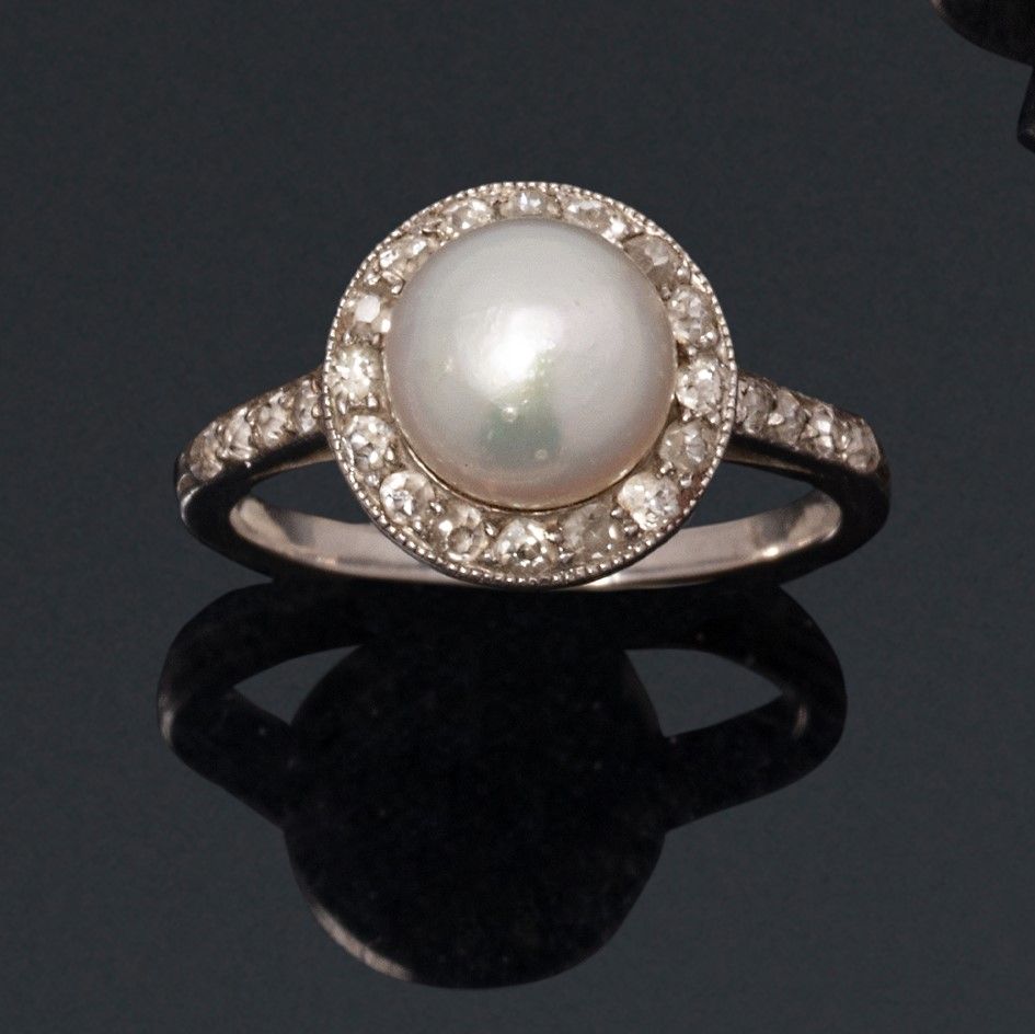 Null 一枚18K(750)白金戒指，以一颗精美的纽扣珍珠为中心，周围和肩部镶有8/8切割钻石。

约1920年。

犀牛头标志。

伴随着LFG的分析报告，&hellip;