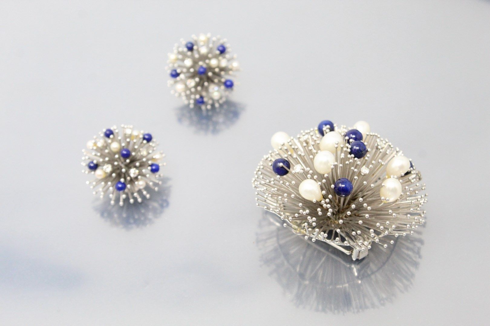 Null 18K（750）白金，青金石球和白色养殖珍珠 "海胆 "半套，由一个胸花夹和一对耳夹组成。

约1960/1970年。

有印记。

胸部夹子的直径：&hellip;