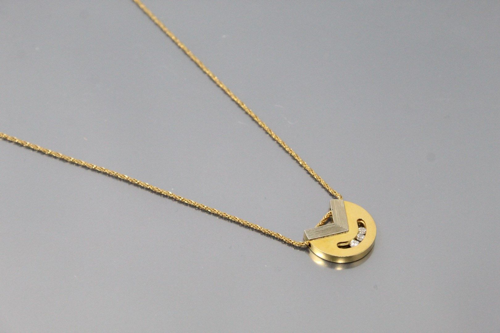 Null 一件18K（750）黄金和白金镂空吊坠，镶有三颗滑动式明亮型切割钻石，并附有一条18K（750）黄金躯干链，带龙虾扣。

图案的尺寸：2.2厘米。- &hellip;