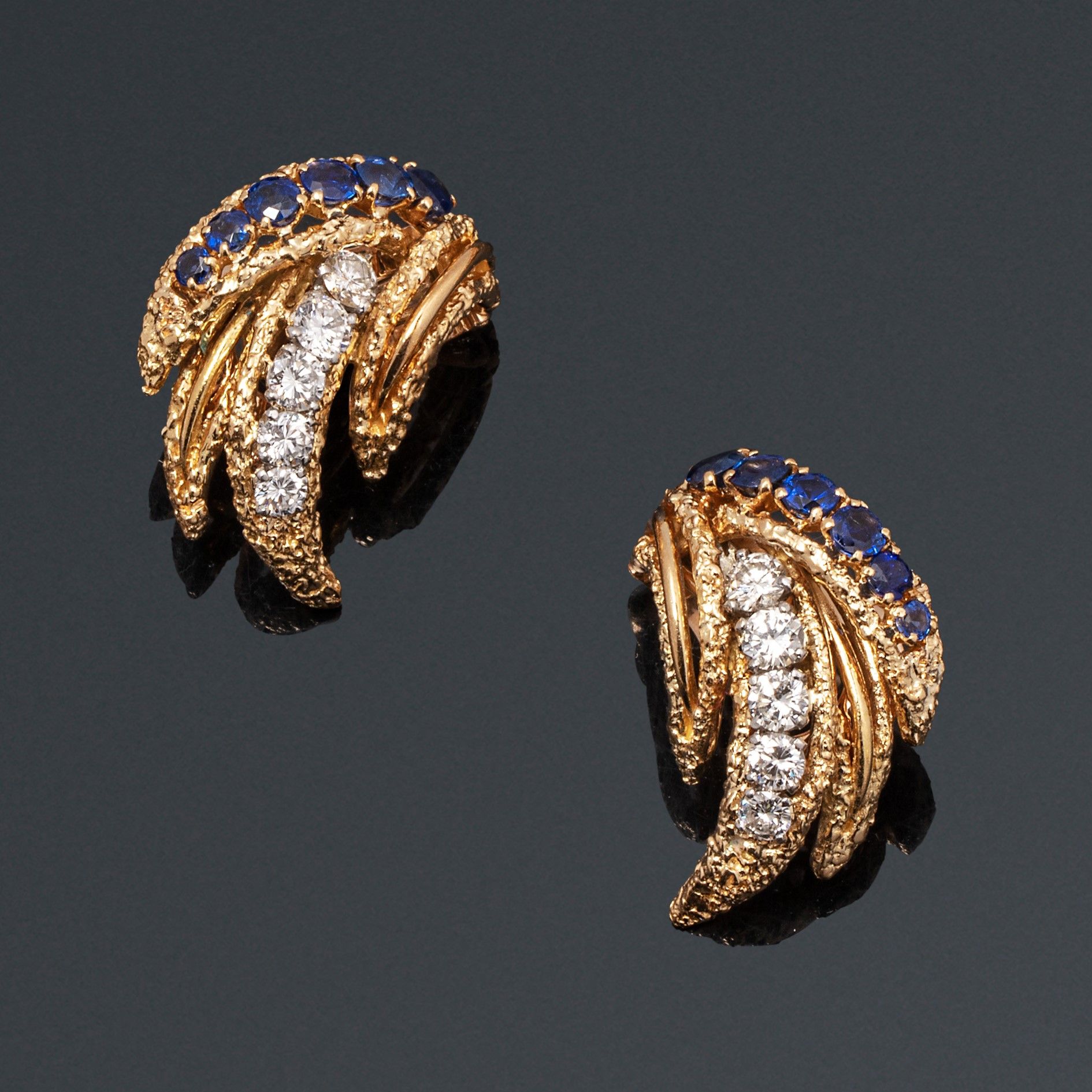 Null 梵克雅宝

一对光滑有质感的18K(750)黄金 "gerbe "耳夹，镶嵌着一排圆形蓝宝石和一排明亮式切割钻石。

约1960年。

穿孔的耳朵系统&hellip;