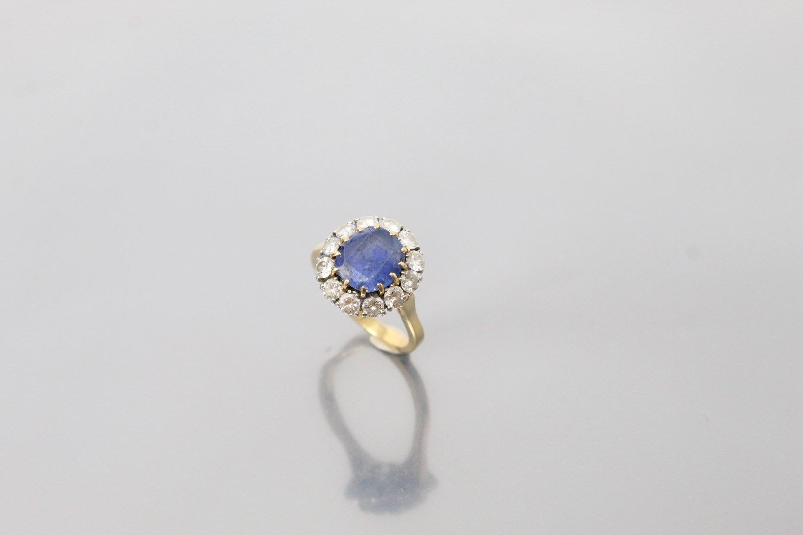 Null 18K（750）黄金雏菊戒指，以枕形蓝宝石为中心，周围是明亮式切割钻石。

手指大小：57 - 毛重：6.82g。

(蓝宝石严重断裂和碎裂，一些钻石&hellip;