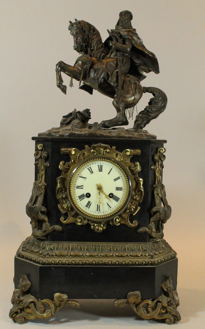 Null 一座黑色大理石钟，带有丰富的铜质装饰，白色珐琅表盘上有罗马数字，上面有一个武装的阿拉伯骑士。

19世纪晚期

高度：58厘米。