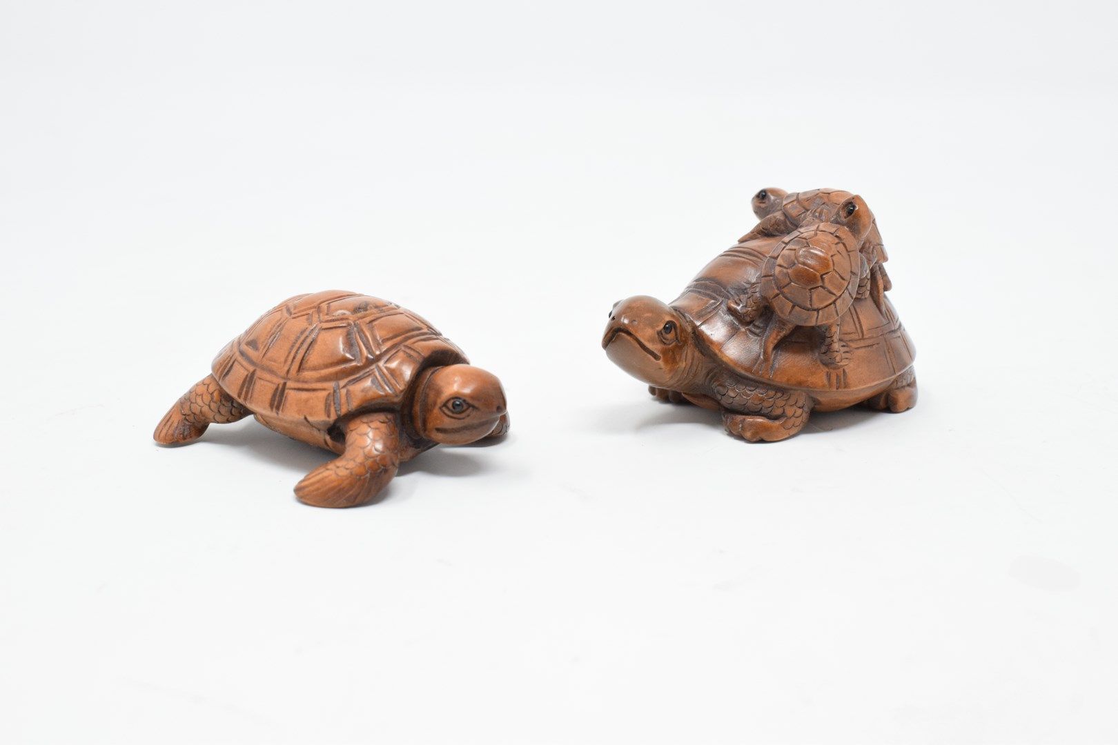 Null 日本 - 20世纪

两件代表两只乌龟的木制网饰，其中一只上有两只小乌龟。

签名。