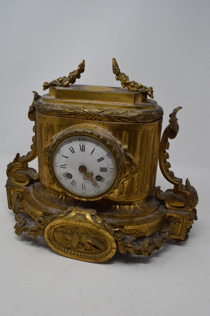 Null Reloj de bronce con pátina dorada que se apoya en una base ovalada decorada&hellip;