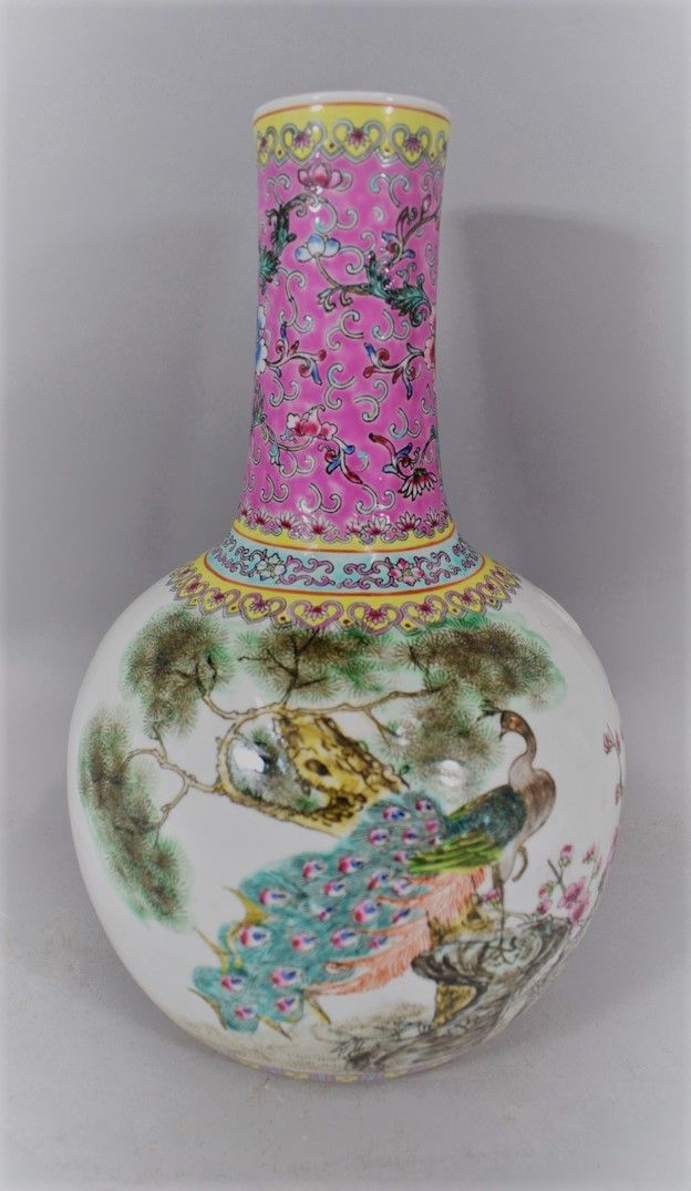 Null 中国--20世纪。

瓷瓶上有多色珐琅彩装饰的岩石上的孔雀，并附有一首诗。

底座上的标记。

H.32