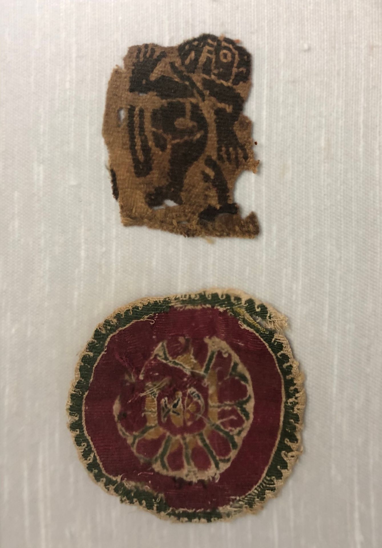Null 埃及，6-8世纪。

两块科普特织物上的刺绣元素碎片，一个是字符，另一个是几何图形的装饰。



直径7厘米和6x5厘米。