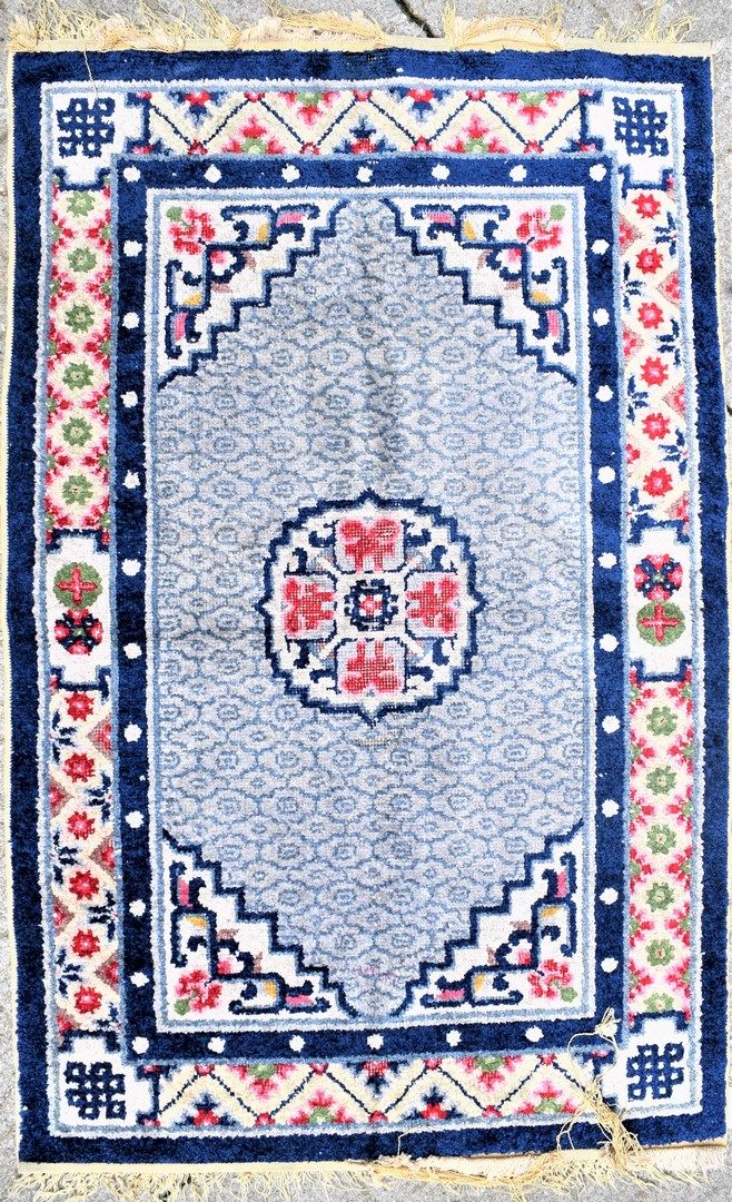 Null 小型羊毛织品地毯

中国，20世纪

在米色背景上装饰有风格化的花卉图案，卐字形图案。

尺寸：厘米。