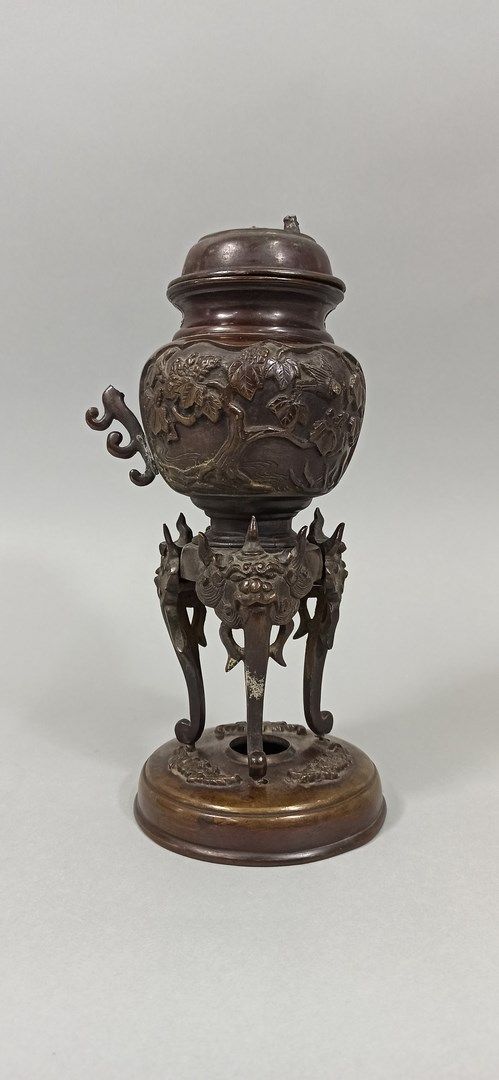 Null 日本 - 明治时期 (1868 - 1912)

一个棕色的青铜香炉，浮雕装饰有帕子，站在三个装饰有狮子头的高脚上，放在一个装饰有树叶的底座上。(手柄&hellip;