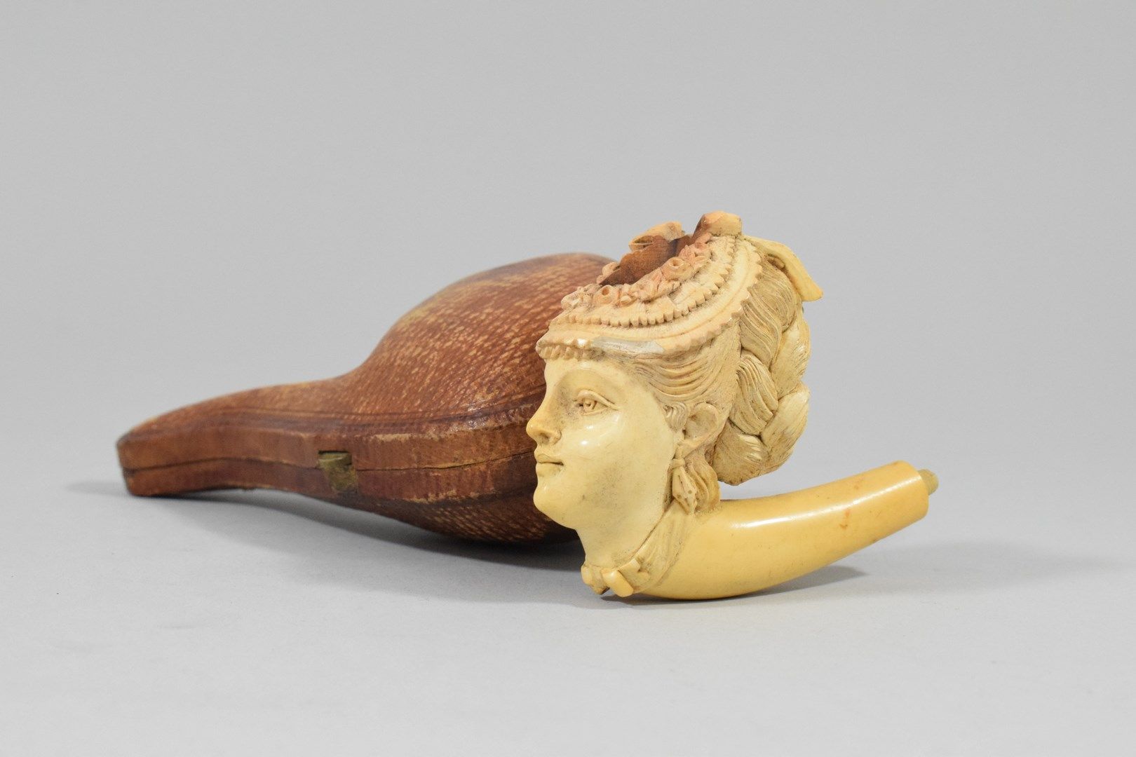 Null 雕刻的梅斯查姆烟斗头，有一个女人的半身像，她的头发扎成了一个发髻，炉膛被一条花色的丝带包围着。

筒子的杆子不见了，在它的箱子里。19世纪晚期。

高&hellip;