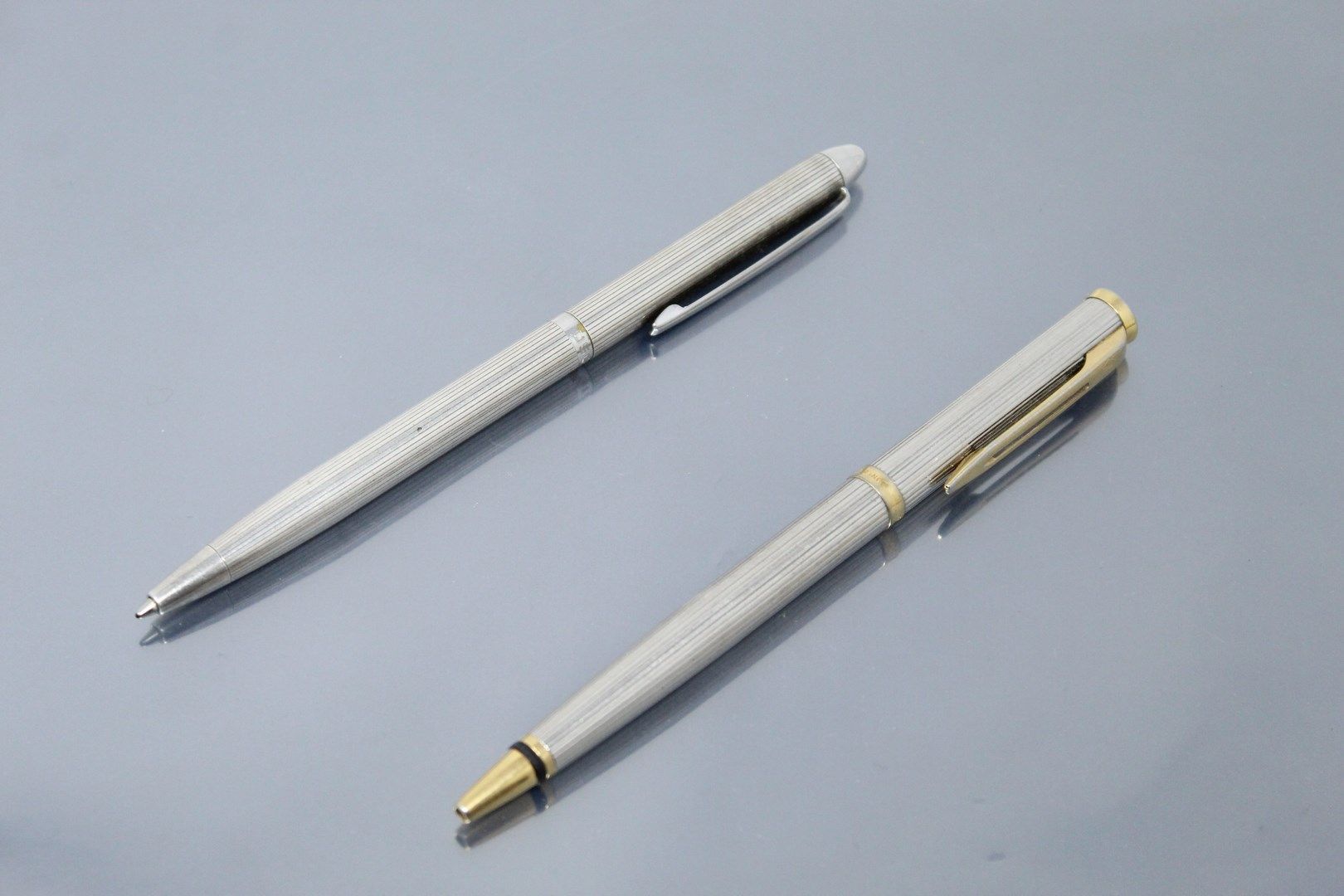 Null 一套两支笔，一支银质笔，署名 "USUS"，另一支金属和鎏金笔，署名 "WATERMAN"。

银器的毛重：24.23克。