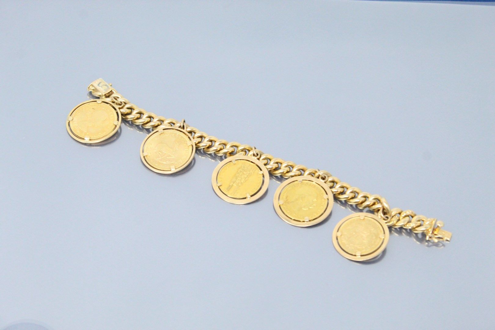 Null Curb in 18k (750) yellow gold decorated with gold coins including: 

- 10 M&hellip;