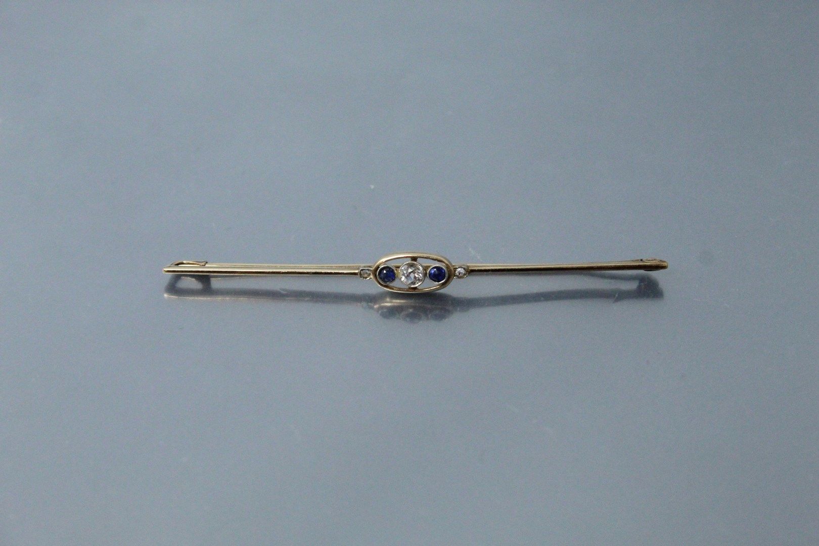 Null 14k(585)黄金胸针，镶有一颗圆形白宝石和两颗蓝宝石。

毛重：2.66克。