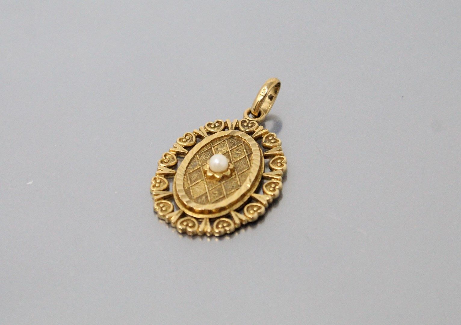 Null 
Colgante calado ovalado de oro amarillo de 14k (585) con una perla. 




P&hellip;