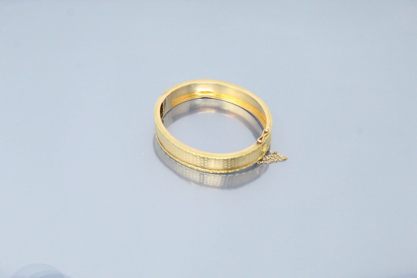 Null Bracelet rigide en or jaune 18k (750) ouvragé d'un semi de fleurettes. 

Po&hellip;