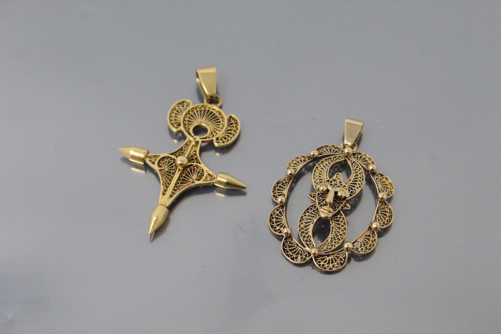 Null Set of two filigree pendants, one styling a cross, the other a mask. 

Weig&hellip;