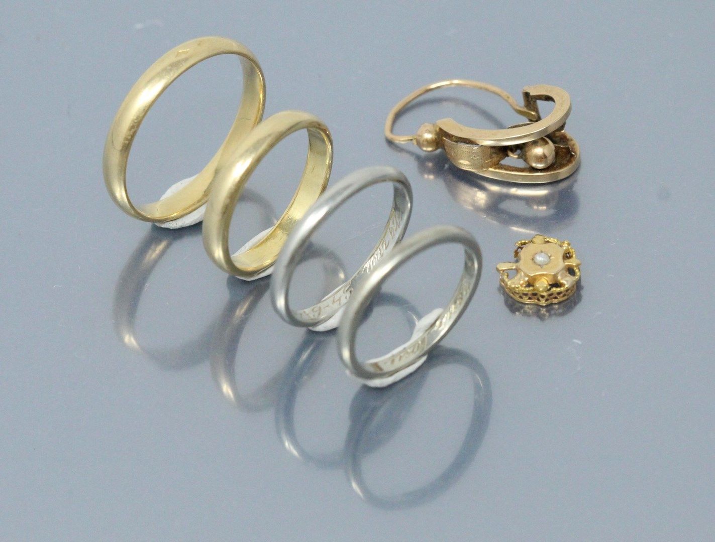 Null 拍品包括一个小碎片、一个耳环和四个结婚戒指：两个白金的，两个黄金的，都是18K的（750）。

重量：12.48克。