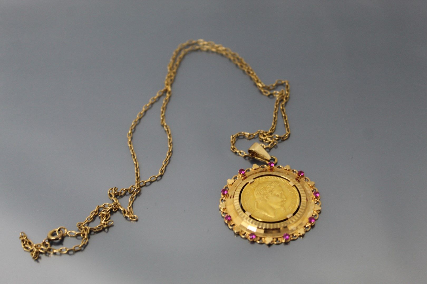 Null 20法郎拿破仑三世头顶桂冠的金币。(1864 A)

18K(750)黄金吊坠，合成红宝石。搭配其18K（750）黄金链。

毛重：18.09克。