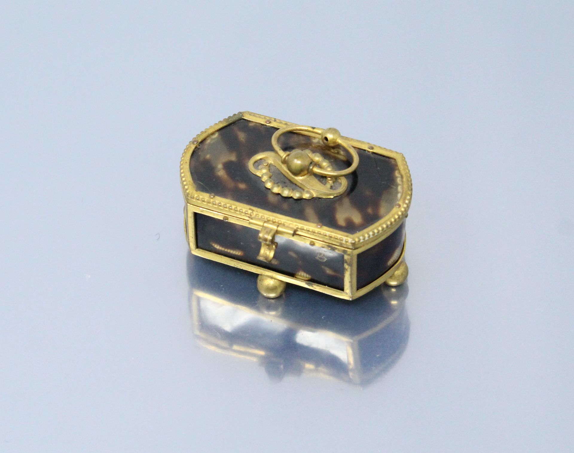 Null 
玳瑁色的小盒子，装在绒球上，放在四个球脚上。19世纪。




尺寸：3x6.50x4厘米。