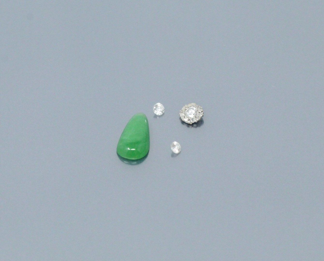 Null Lot of three diamonds and a pear cabochon jade on paper.
