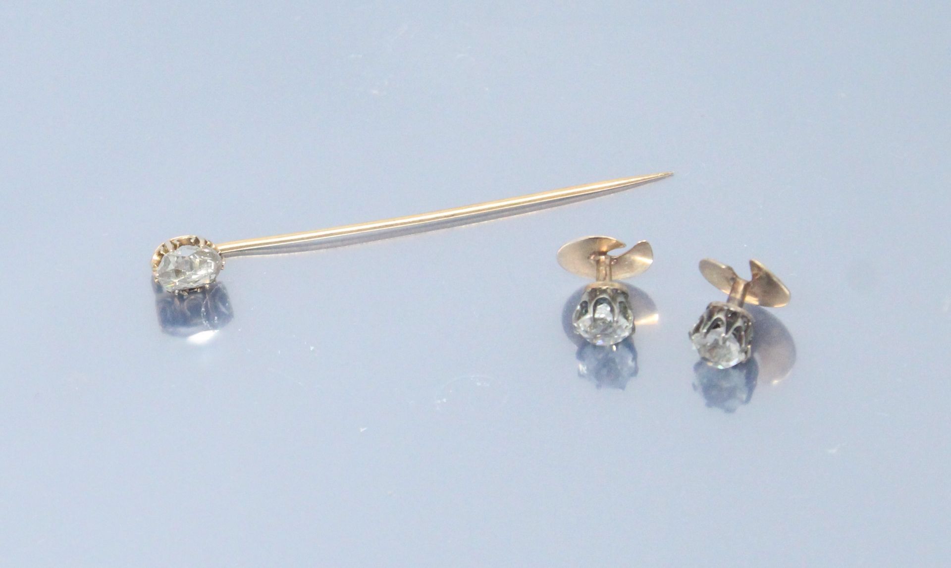 Null 18K黄金（750-马）的领带夹和一对领扣，镶嵌有白色宝石。

毛重：4.60克。