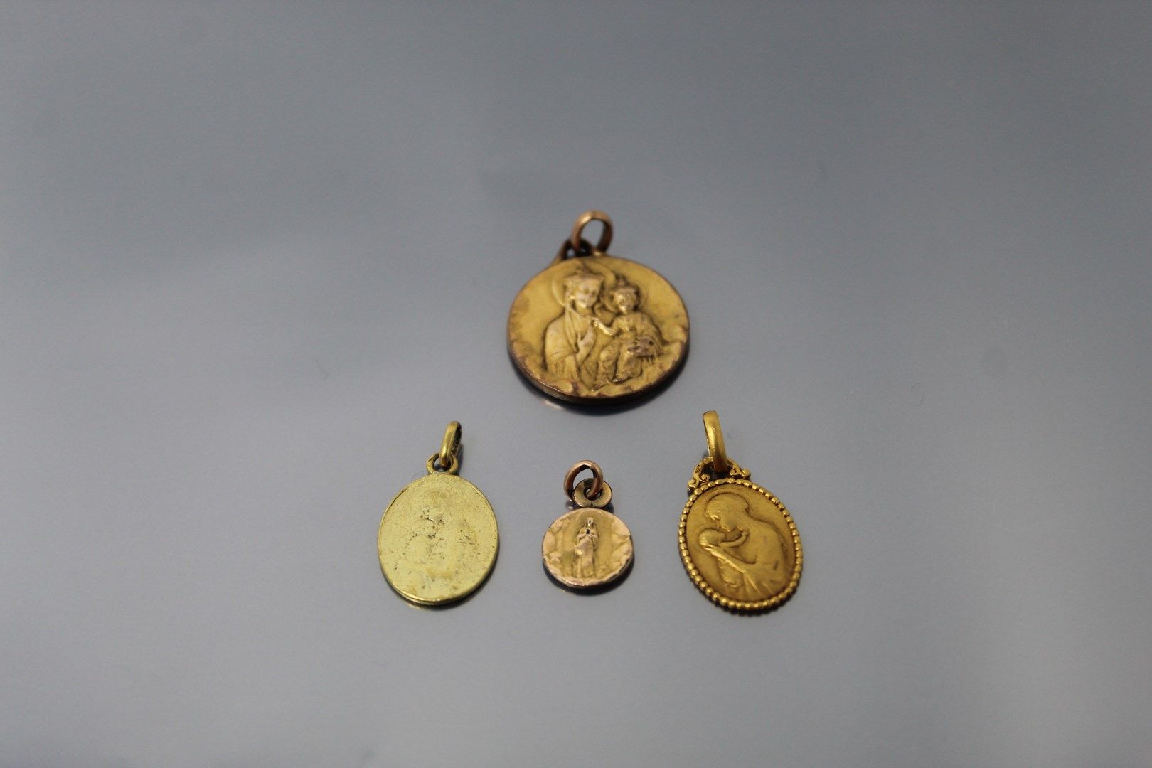 Null 
Lote de cuatro medallas, tres en oro amarillo de 18k (750), una en metal

&hellip;