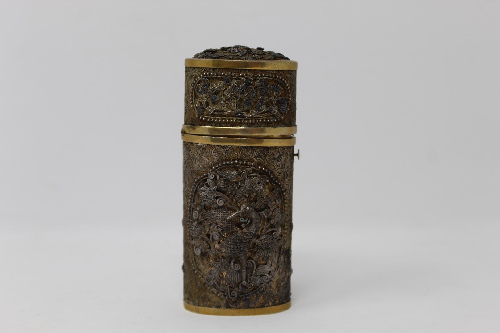 Null 一个有银丝装饰的镀金圆柱形盒子，正面刻有MD，背面是植物框架中的一只鸟；通过按钮打开。

重量：128.60克 - 高度：12厘米。