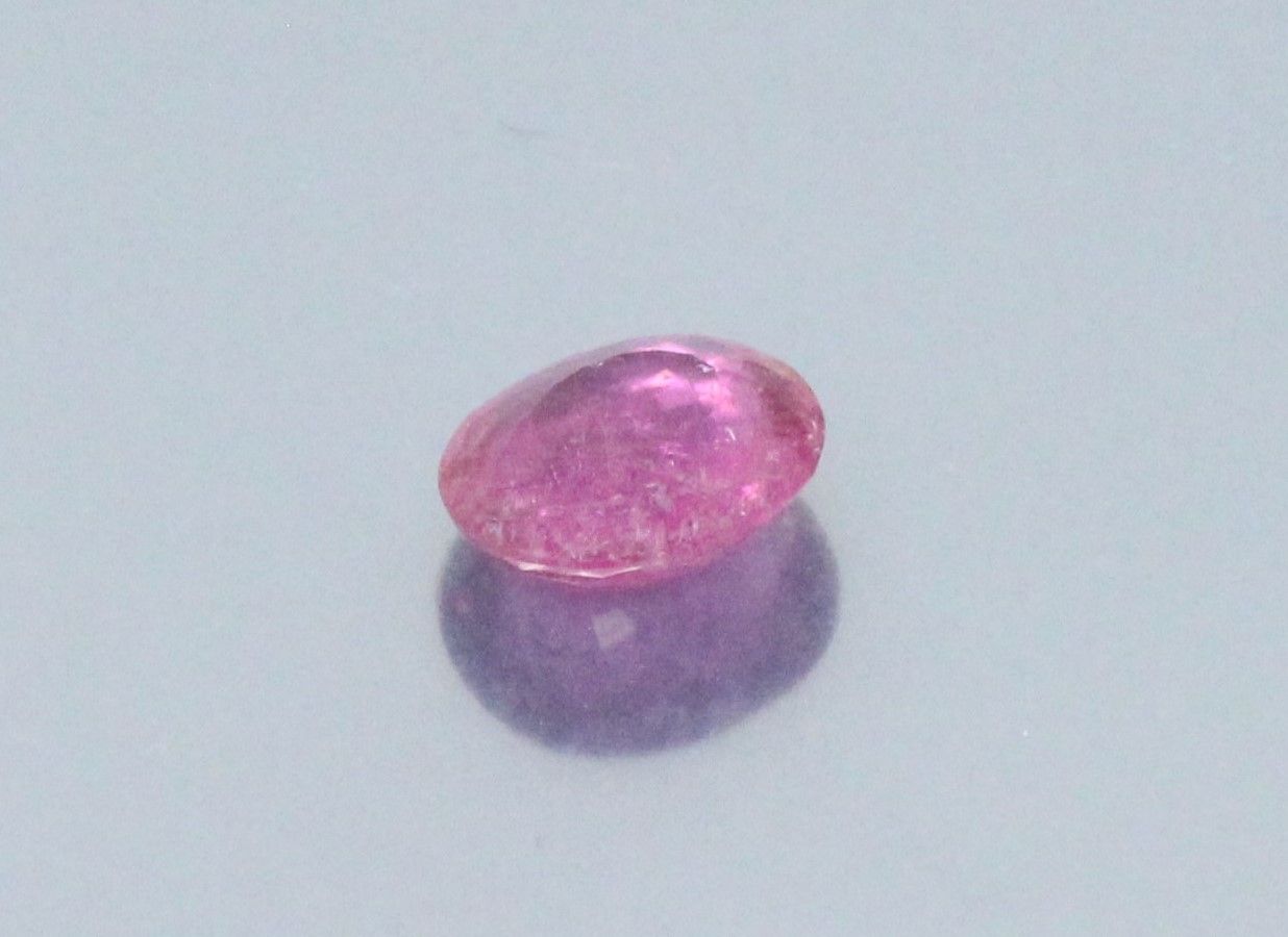 Null Turmalina rosa (rubelita) ovalada sobre papel. 

Peso : 2,71 cts.