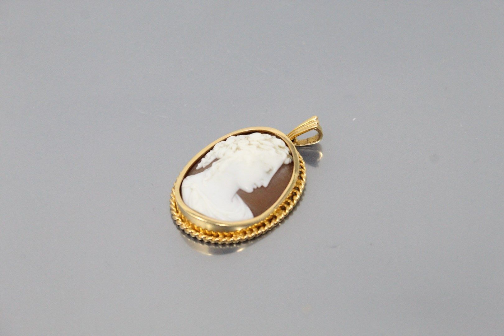 Null An 18k (750) yellow gold pendant with a shell cameo showing a young woman d&hellip;